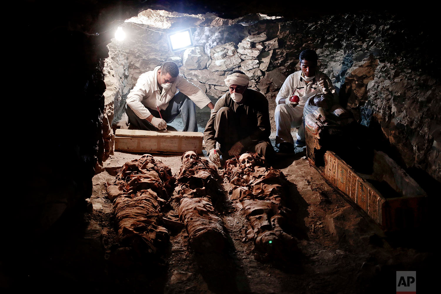 Archaeologists work on mummies found in the New Kingdom tomb that belongs to a royal goldsmith in a burial shaft, in Luxor, Egypt, Saturday, Sept. 9, 2017. Egypt has announced the discovery in the southern city of Luxor of a pharaonic tomb belonging to a royal goldsmith who lived more than 3,500 years ago during the reign of the 18th dynasty. (AP Photo/Nariman El-Mofty)