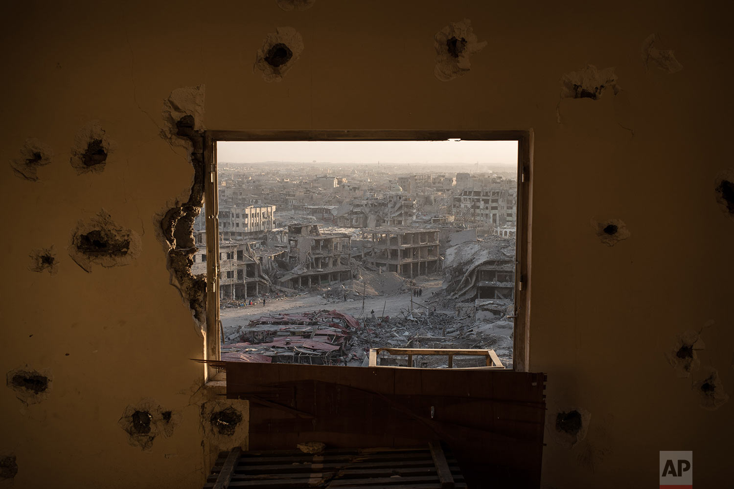 In this July 11, 2017 photo, destroyed buildings are framed by the window of a damaged hotel on the west side of Mosul, Iraq. Iraq???s U.S.-backed forces succeeded in wresting Mosul from the Islamic State group but at the cost of enormous destruction. The nearly 9-month fight culminated in a crescendo of devastation _ the blasting of the historic Old City to root out the militants??? final pockets. (AP Photo/Felipe Dana)