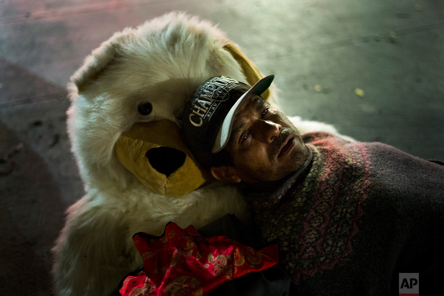 Using a teddy bear named Michelle as a pillow, Manuel Martinez, a 45-year-old homeless day laborer originally from Mexico, falls asleep on a sidewalk in the Skid Row area of downtown Los Angeles, Thursday, Nov. 2, 2017. Martinez said he has been an alcoholic more than a decade. (AP Photo/Jae C. Hong)