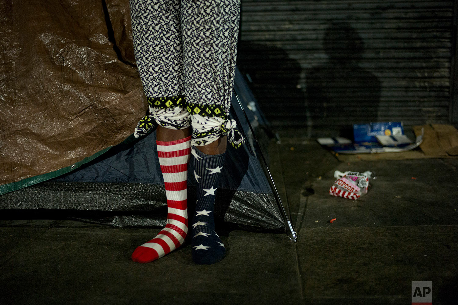 Wearing a pair of American flag socks, homeless Stafford Wilson, 48, stands in front of his tent while dancing to music Tuesday, Nov. 7, 2017, in the Skid Row area of downtown Los Angeles. (AP Photo/Jae C. Hong)