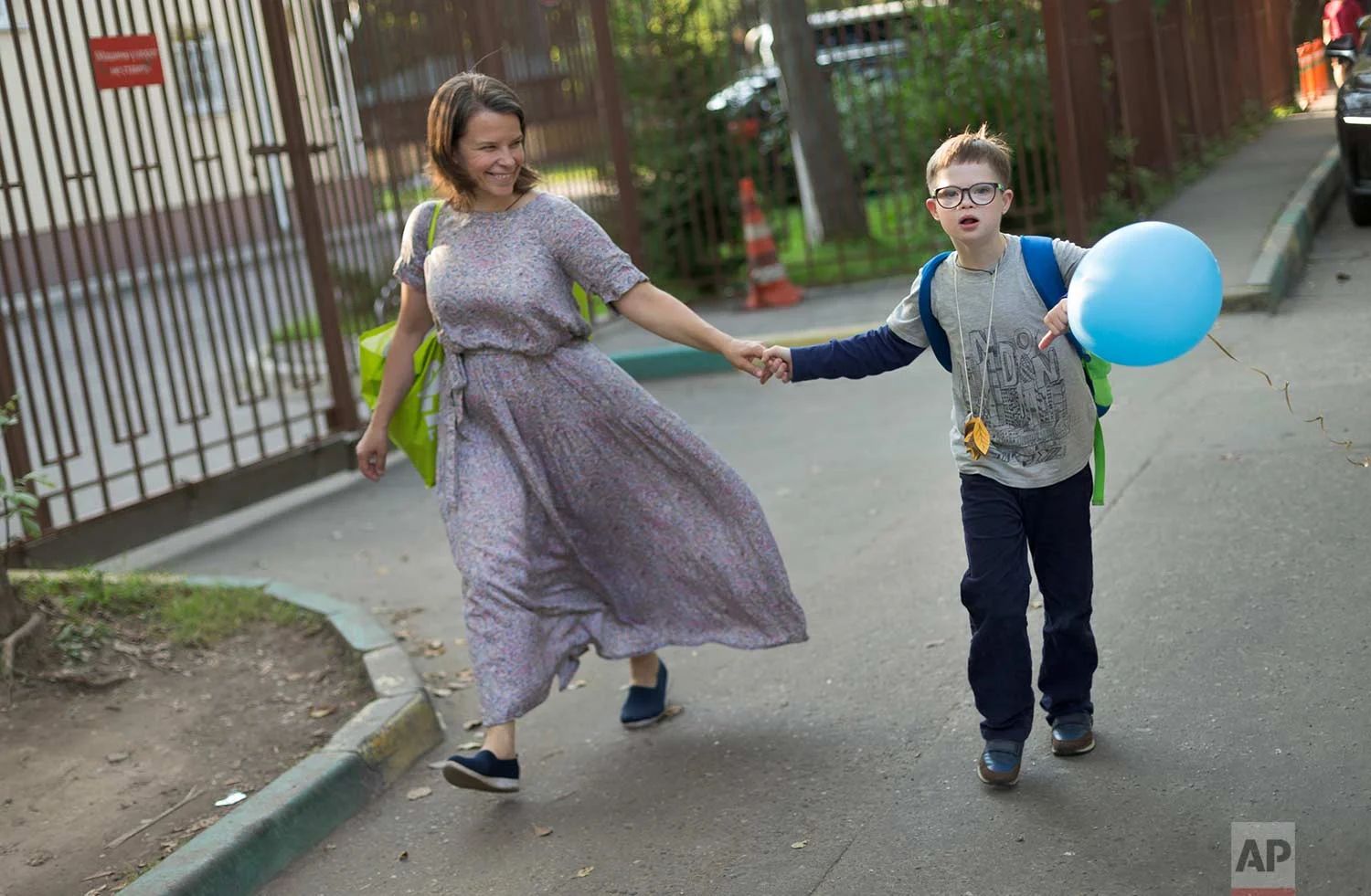 Volunteer Valentina and former 11-year-old pupil Gleb walk home after visiting the St. Sophia orphanage in Moscow, Russia, on Tuesday, Sept. 12, 2017. (AP Photo/Ivan Sekretarev)