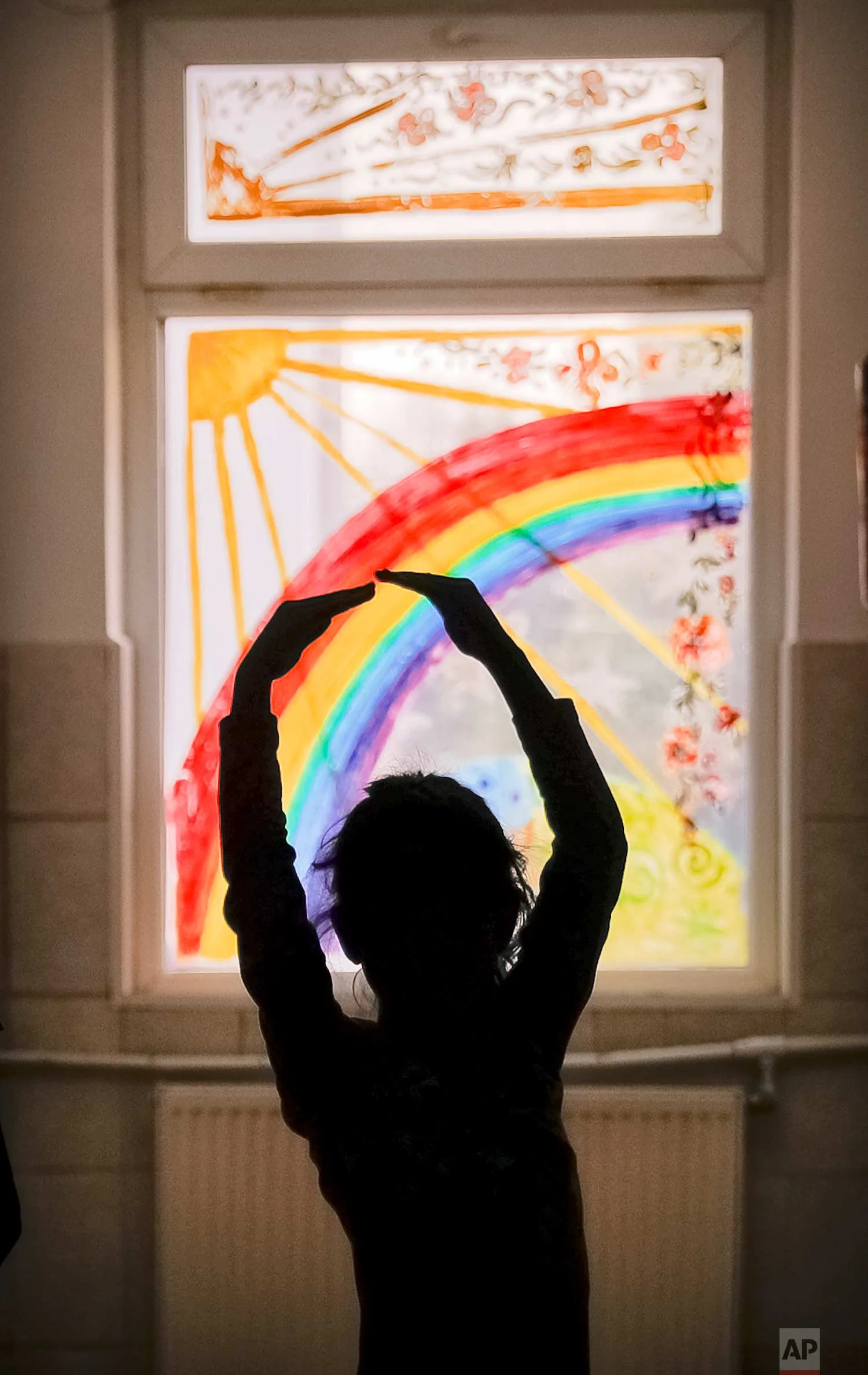 Sara, a child living at the Robin Hood orphanage, tries a ballet move while posing on a corridor with painted windows, in Bucharest, Romania, on Friday, Nov. 3, 2017. (AP Photo/Vadim Ghirda)