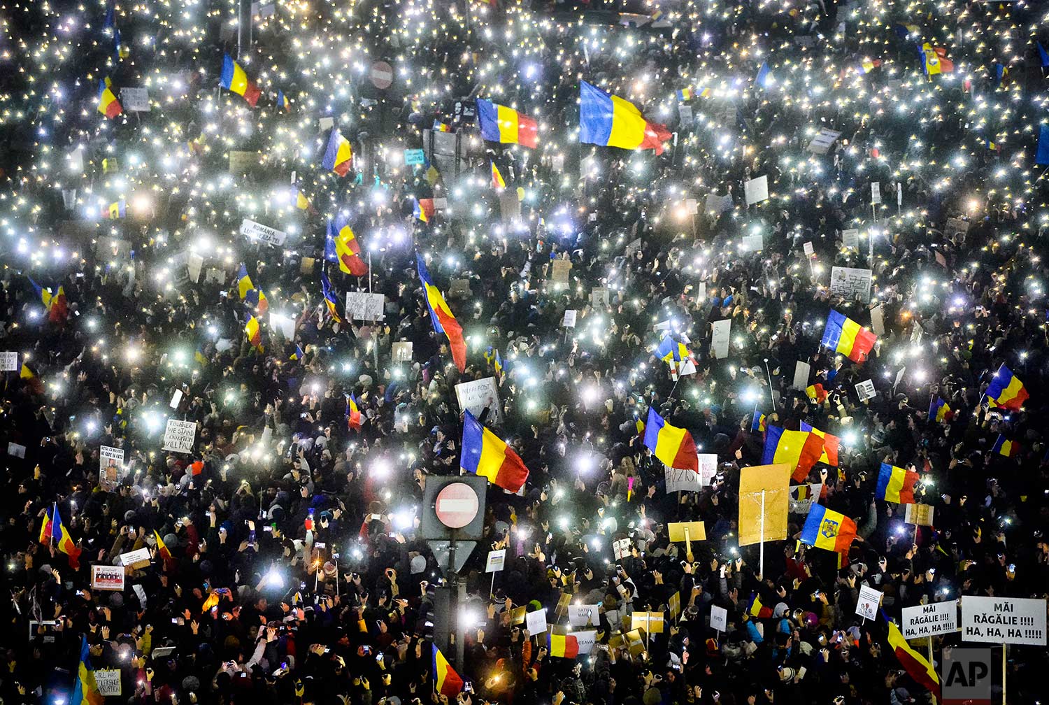  In this Sunday, Feb. 5, 2017 photo, tens of thousands of people shine lights from mobile phones and torches during a protest in front of the government building in Bucharest, Romania. Romania's government met Sunday to repeal an emergency decree tha