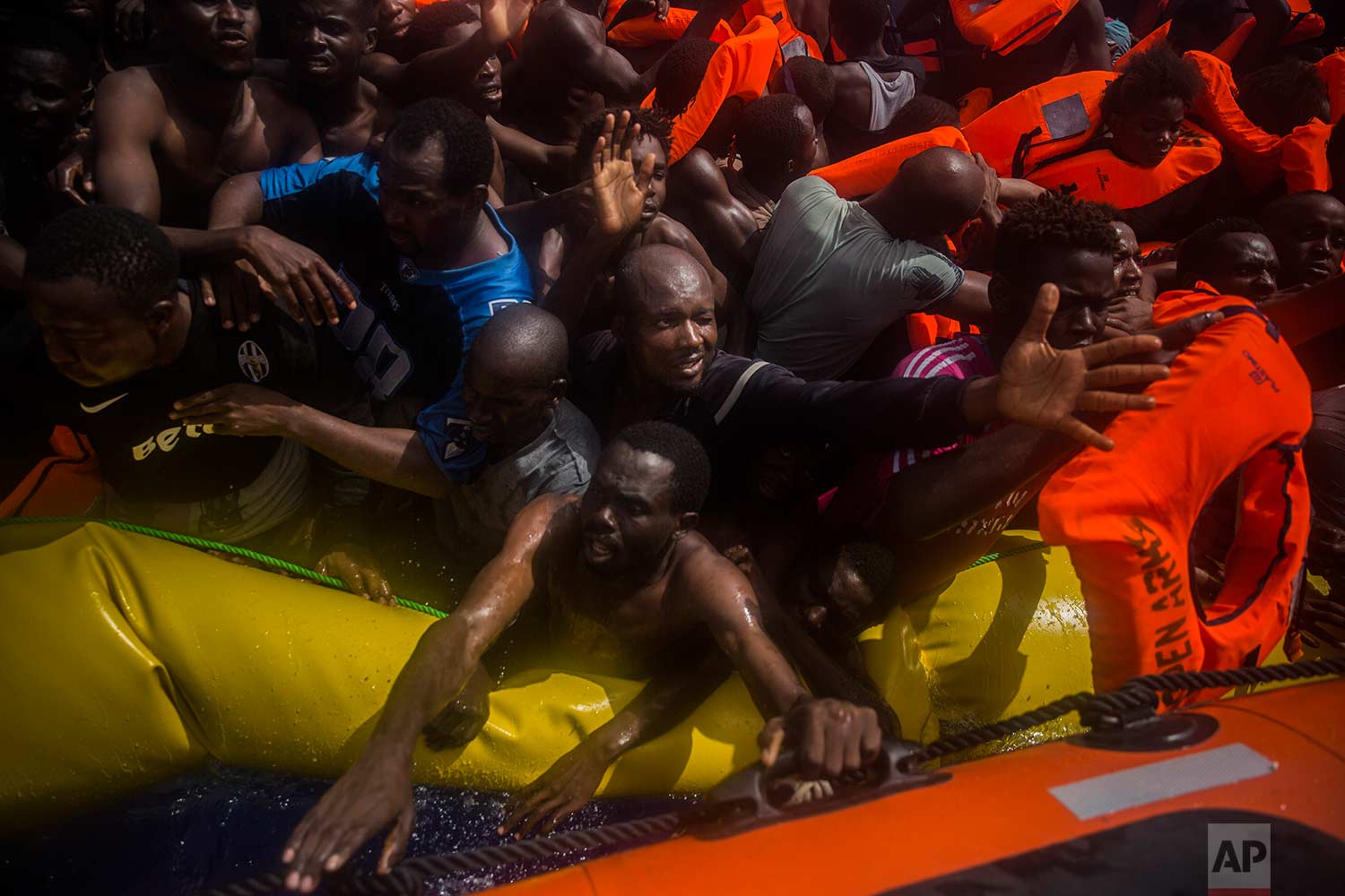  In this Tuesday, July 25, 2017 photo, sub-Saharan migrants receive life jackets as they are rescued by aid workers of Spanish NGO Proactiva Open Arms in the Mediterranean Sea, about 15 miles north of Sabratha, Libya. (AP Photo/Santi Palacios)
 