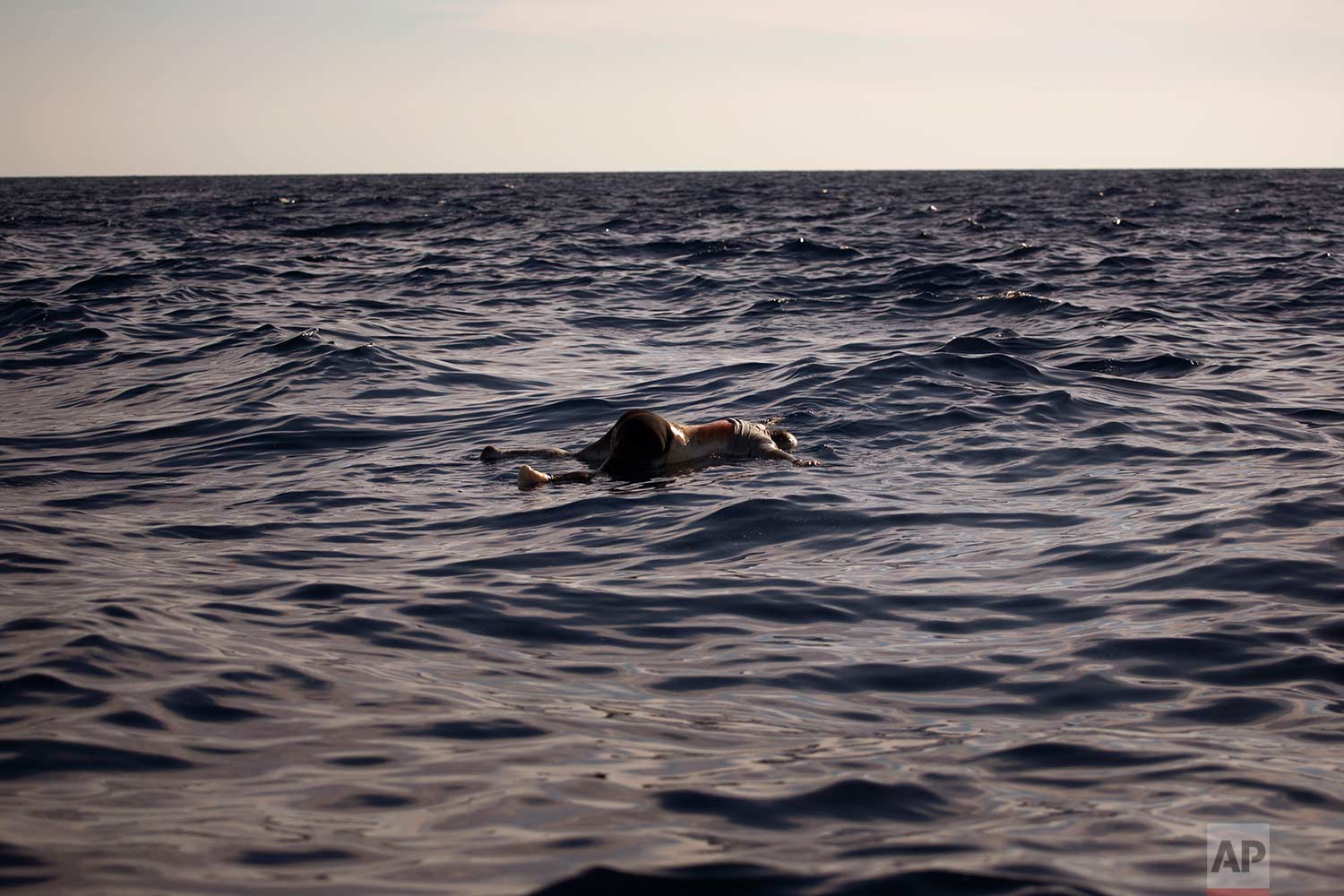  In this Wednesday, June 21, 2017 photo, a dead body of a woman is seen floating on the mediterranean sea, at 20 miles north of Zuwarah, Libya. At least three bodies with sign of decompositions were found by aid organisations on Wednesday, apparently