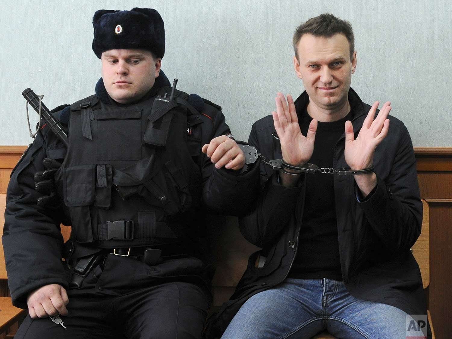  In this Thursday, March 30, 2017 photo, Russian opposition leader Alexei Navalny, right, poses for press in court in Moscow, Russia. Navalny attends a court hearing on his appeal. Navalny, who organized a wave of nationwide protests against governme
