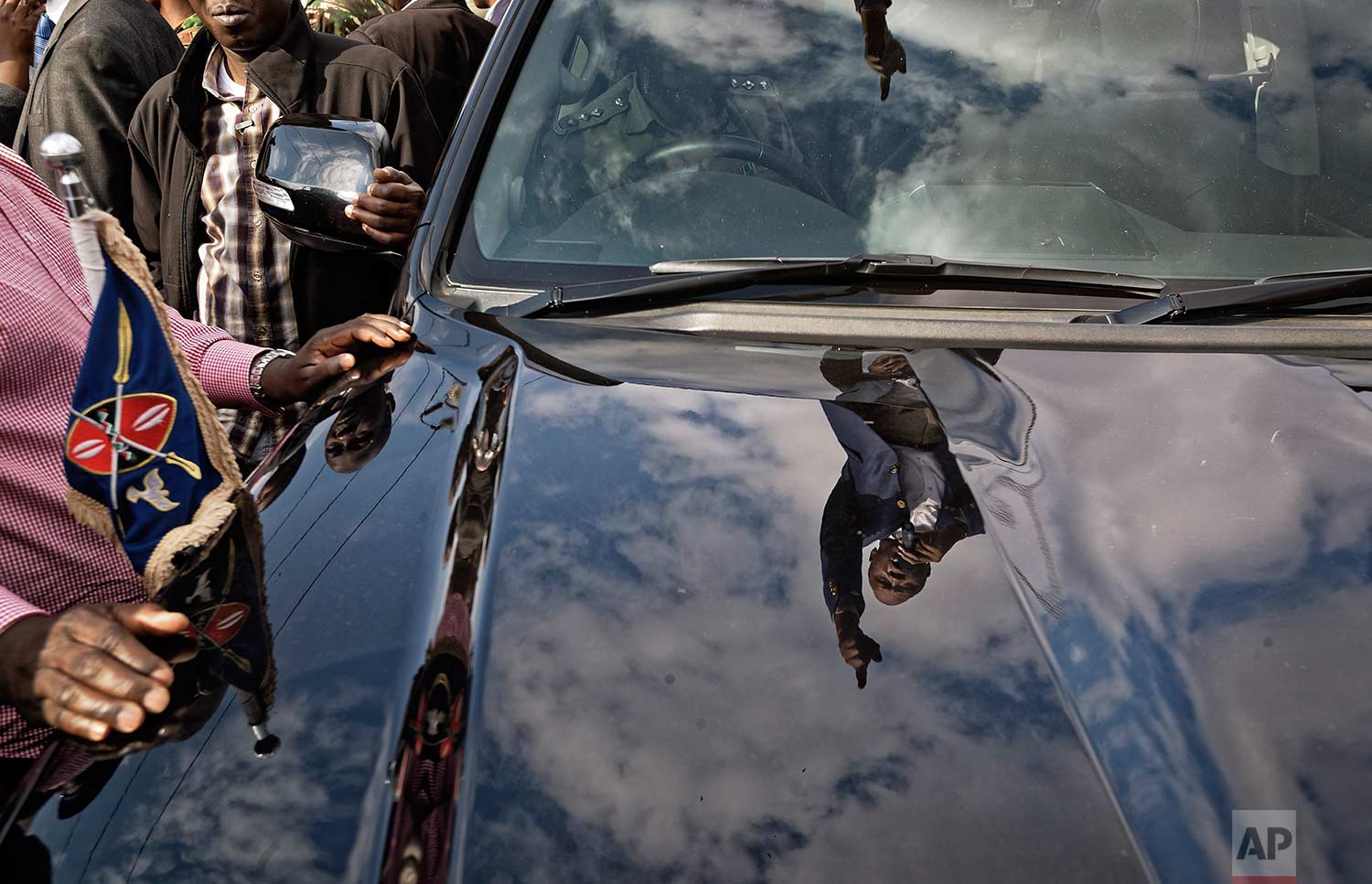  In this Tuesday, Sept. 5, 2017 photo, Kenya's President Uhuru Kenyatta is  reflected in the hood of the presidential vehicle in which he is standing, addresses his supporters on a street in Ongata Rongai, on the outskirts of Nairobi, Kenya. (AP Phot