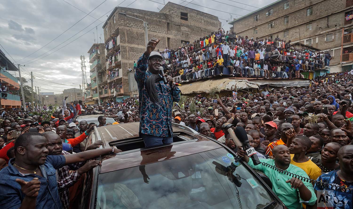  In this Sunday, Aug. 13, 2017 photo, Kenyan opposition leader Raila Odinga gestures to thousands of supporters gathered in the Mathare slum of Nairobi, Kenya. Odinga on Sunday condemned police killings of rioters during protests after the country's 