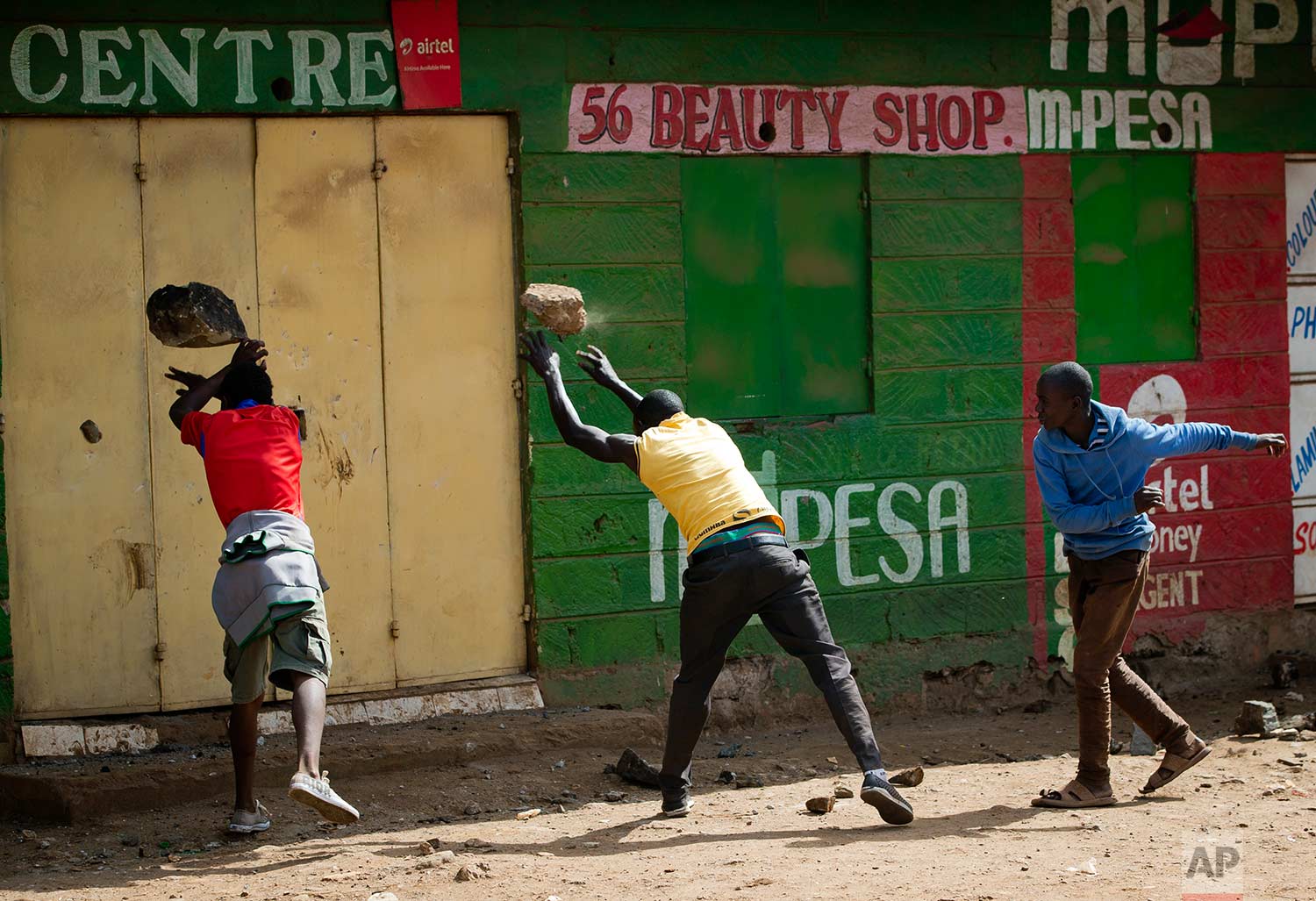  In this Saturday, Oct. 28, 2017 photo, opposition supporters attempt to break the door of a shop in order to loot it, in the slum of Kawangware in Nairobi, Kenya. Kenyan opposition areas were calmer Saturday, a day after the country's election commi