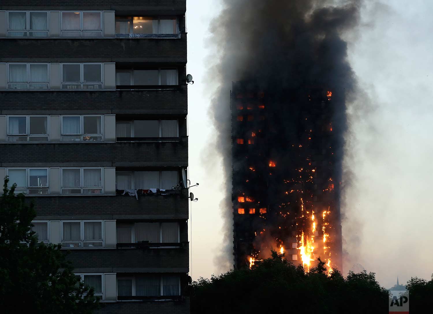  In this Wednesday, June 14, 2017 photo, smoke and flames rise from the Grenfell Tower high-rise building in west London. (AP Photo/Matt Dunham) 