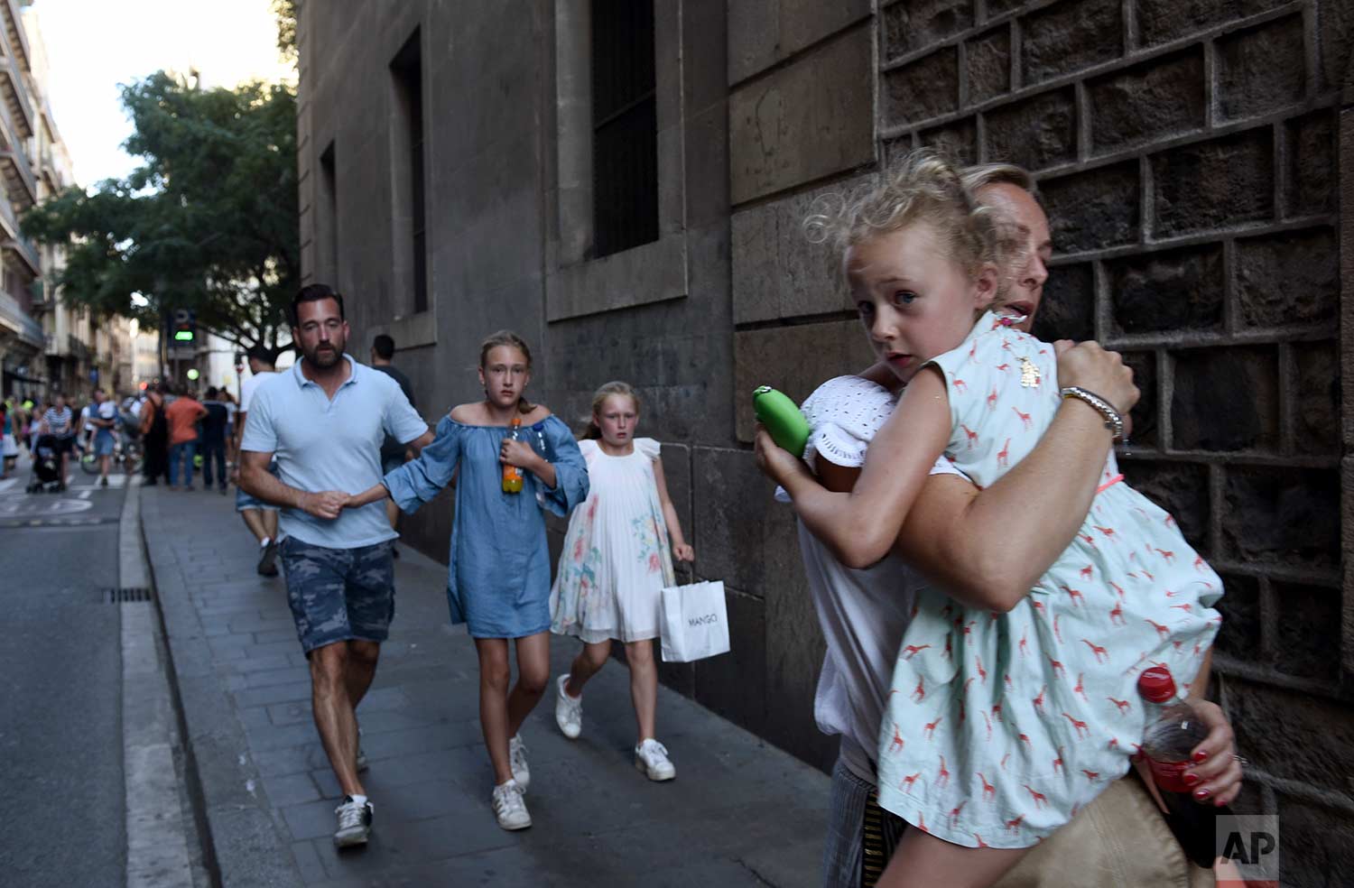  People flee the scene in Barcelona, Spain, on Aug. 17, 2017, after a van jumped the sidewalk in the historic Las Ramblas district, crashing into a summer crowd of residents and tourists and injuring several people. (AP Photo/Giannis Papanikos) 