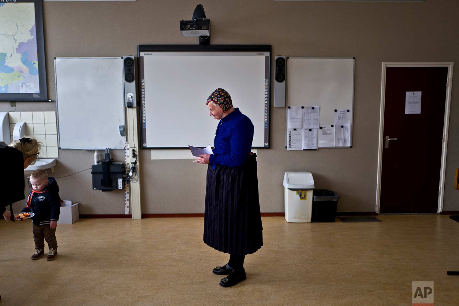  In this Wednesday, March 15, 2017 photo, an elderly woman wearing a traditional hat waits her turn to cast her vote for the Dutch general elections at a polling station in a school in Staphorst, Netherlands. Mark Rutte, the Dutch prime minister who 