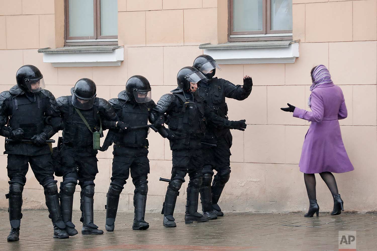  In this Saturday, March 25, 2017 photo, a woman argues as Belarus police block a street during an opposition rally in Minsk, Belarus. A cordon of club-wielding police blocked the demonstrators' movement along Minsk's main avenue near the Academy of 
