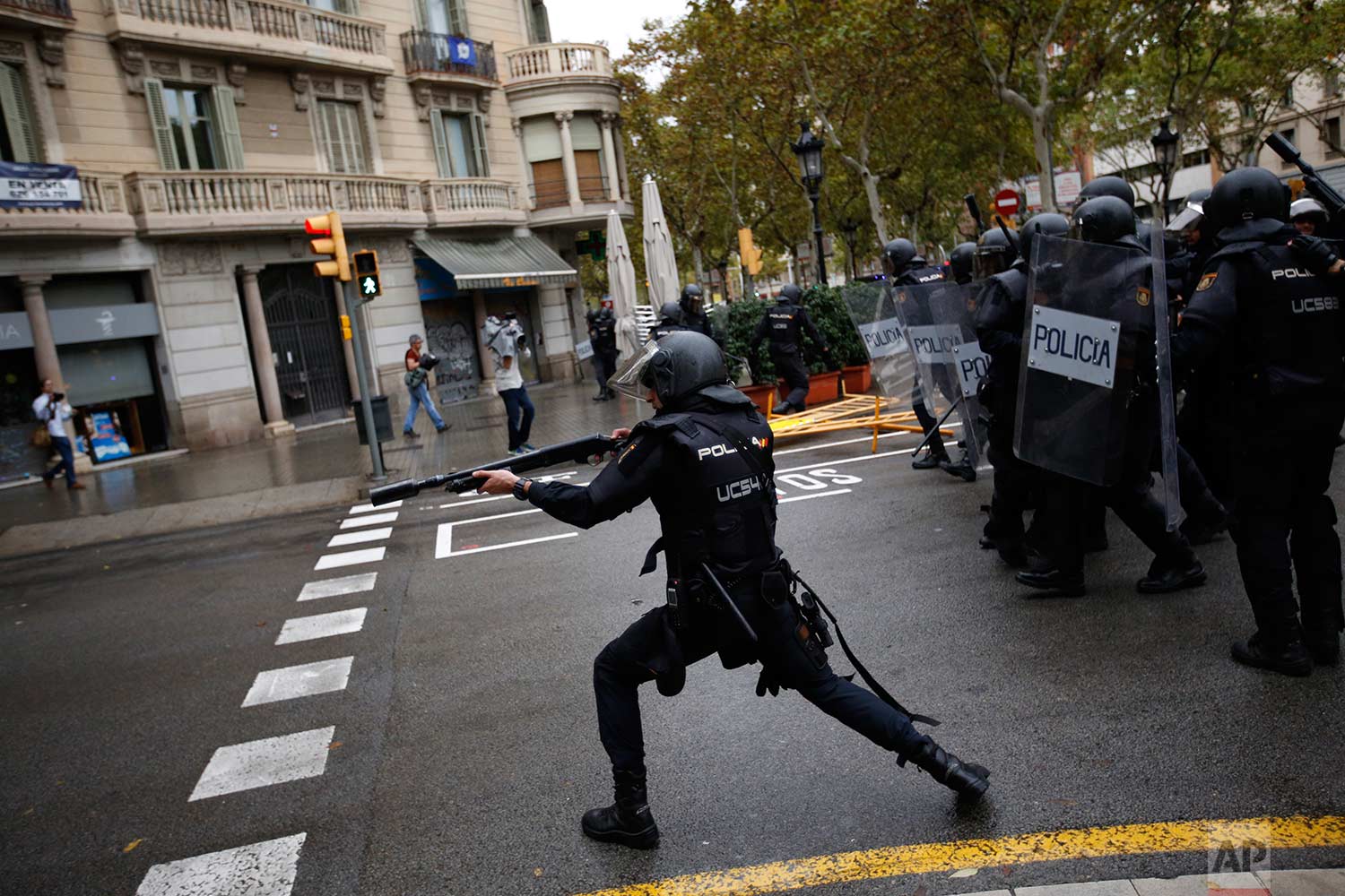 In this Sunday, 1 Oct. 2017 photo, Spanish riot police shoots rubber bullet straight to people trying to reach a voting site at a school assigned to be a polling station by the Catalan government in Barcelona, Spain. (AP Photo/Emilio Morenatti) 