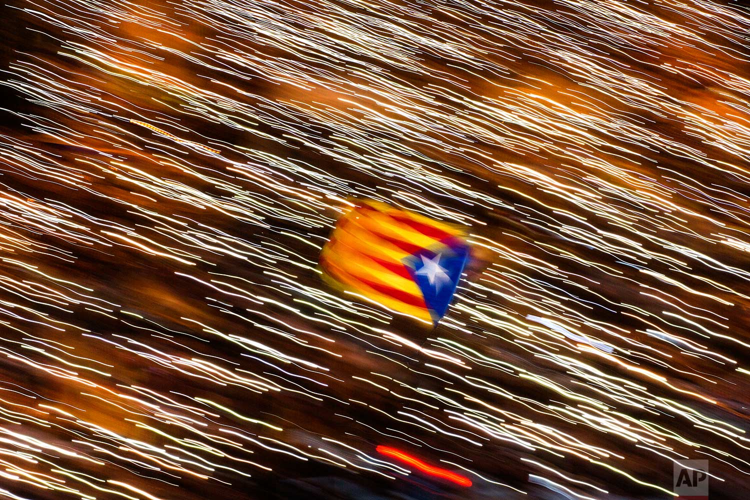 In this Saturday, Nov 11, 2017 photo, an independence flag is waved as demonstrators take part at a protest calling for the release of Catalan jailed politicians, in Barcelona, Spain. Eight members of the now-defunct Catalan government remain jailed