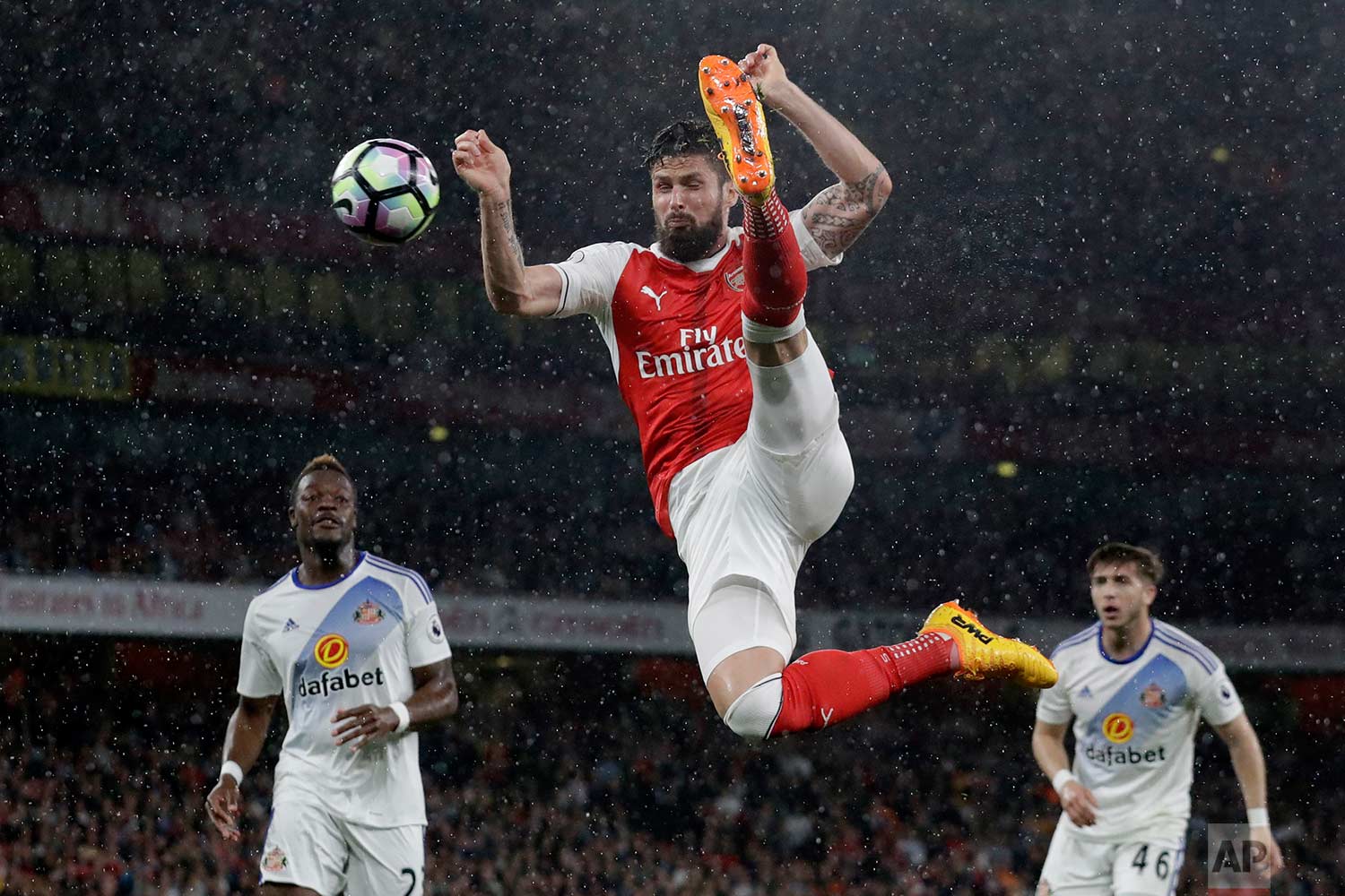  In this Tuesday, May 16, 2017 photo, Arsenal's Olivier Giroud hits the ball across goal, which Alexis Sanchez scored their side's second goal from during the English Premier League soccer match between Arsenal and Sunderland at the Emirates Stadium 
