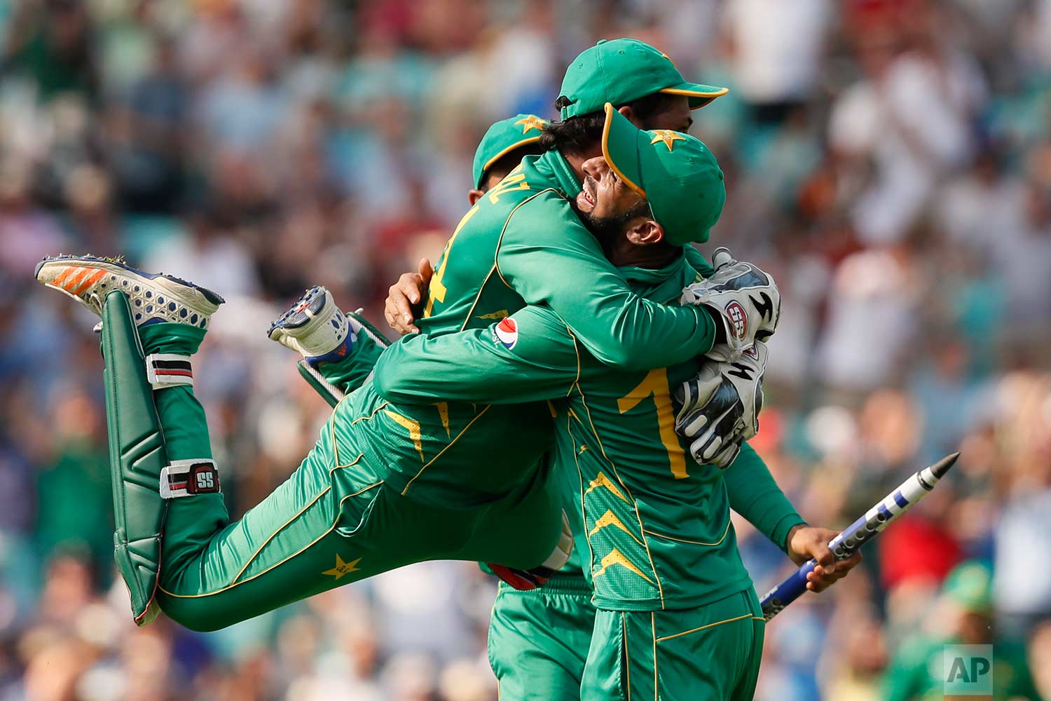  In this Sunday, June 18, 2017 photo, Pakistan's captain Sarfraz Ahmed, left, jumps over a teammate after they defeated India by 180 runs during the ICC Champions Trophy final at The Oval in London. (AP Photo/Kirsty Wigglesworth) 