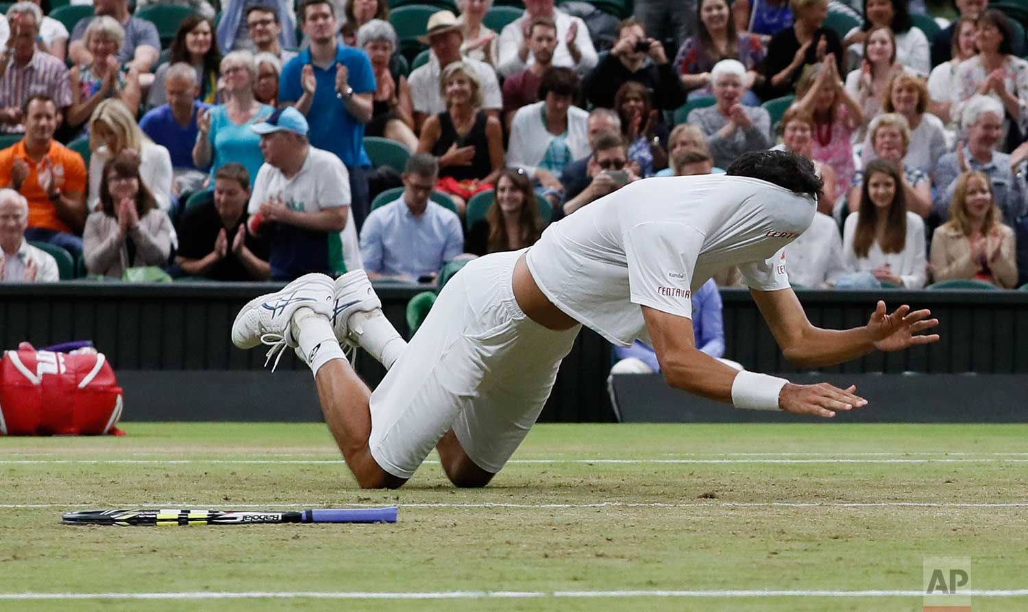  In this Saturday, July 15, 2017 photo, Brazil's Marcelo Melo falls to the ground with his shirt covering his face as he celebrates after he and his playing partner Poland's Lukasz Kubot, defeated Austria's Oliver Marach, and Croatia's Mate Pavic in 