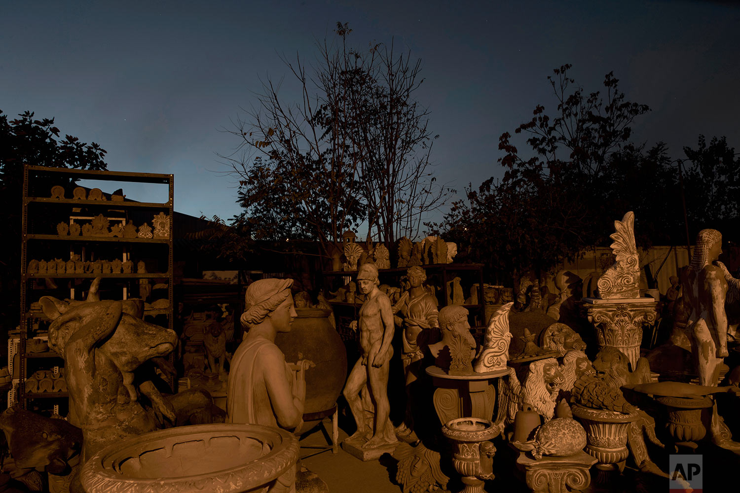  In this Friday, Nov. 20, 2017 photo, the terracotta statue of Ares, the ancient Greek god of war, middle, stands among other statues, busts, antefixes and flowers pots in the yard of Haralambos Goumas' sculpture and ceramic workshop, in the Egaleo s