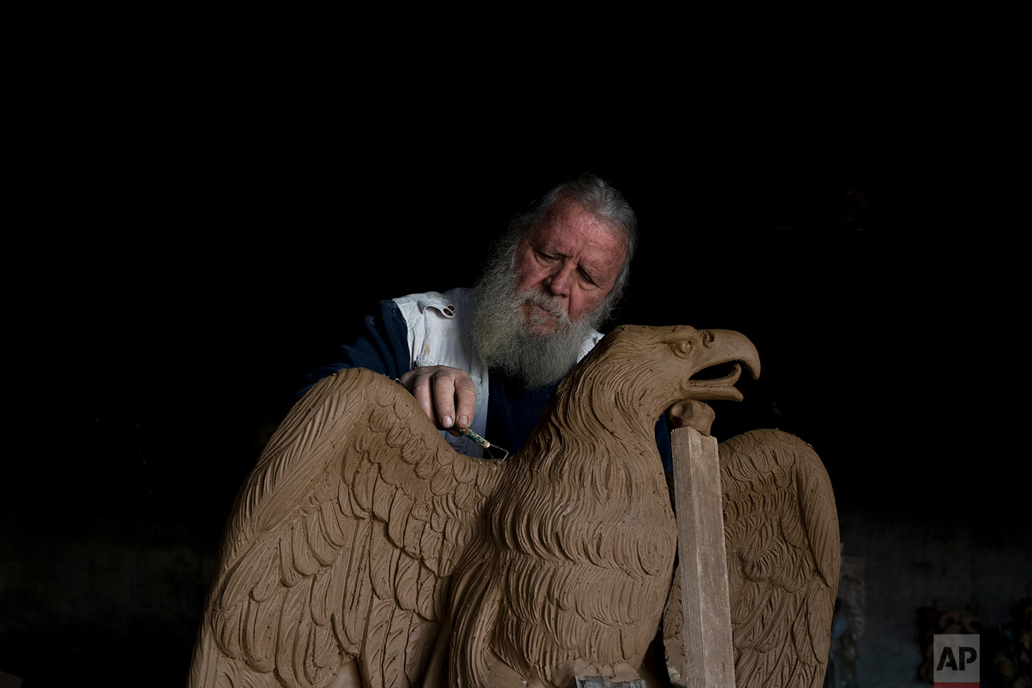  In this Tuesday, Nov. 14, 2017 photo, sculptor and ceramicist Haralambos Goumas works on a terracotta eagle, at his workshop, in the Egaleo suburb of Athens.  (AP Photo/Petros Giannakouris) 