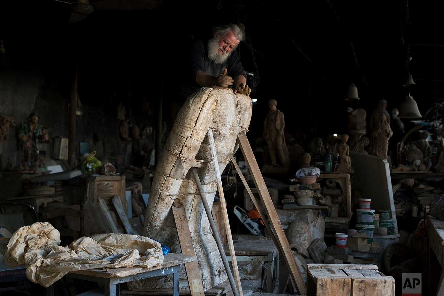  In this Thursday, Oct. 19, 2017 photo, sculptor and ceramicist Haralambos Goumas works on a huge terracotta eagle in a mould, at his workshop, in the Egaleo suburb of Athens.  (AP Photo/Petros Giannakouris) 