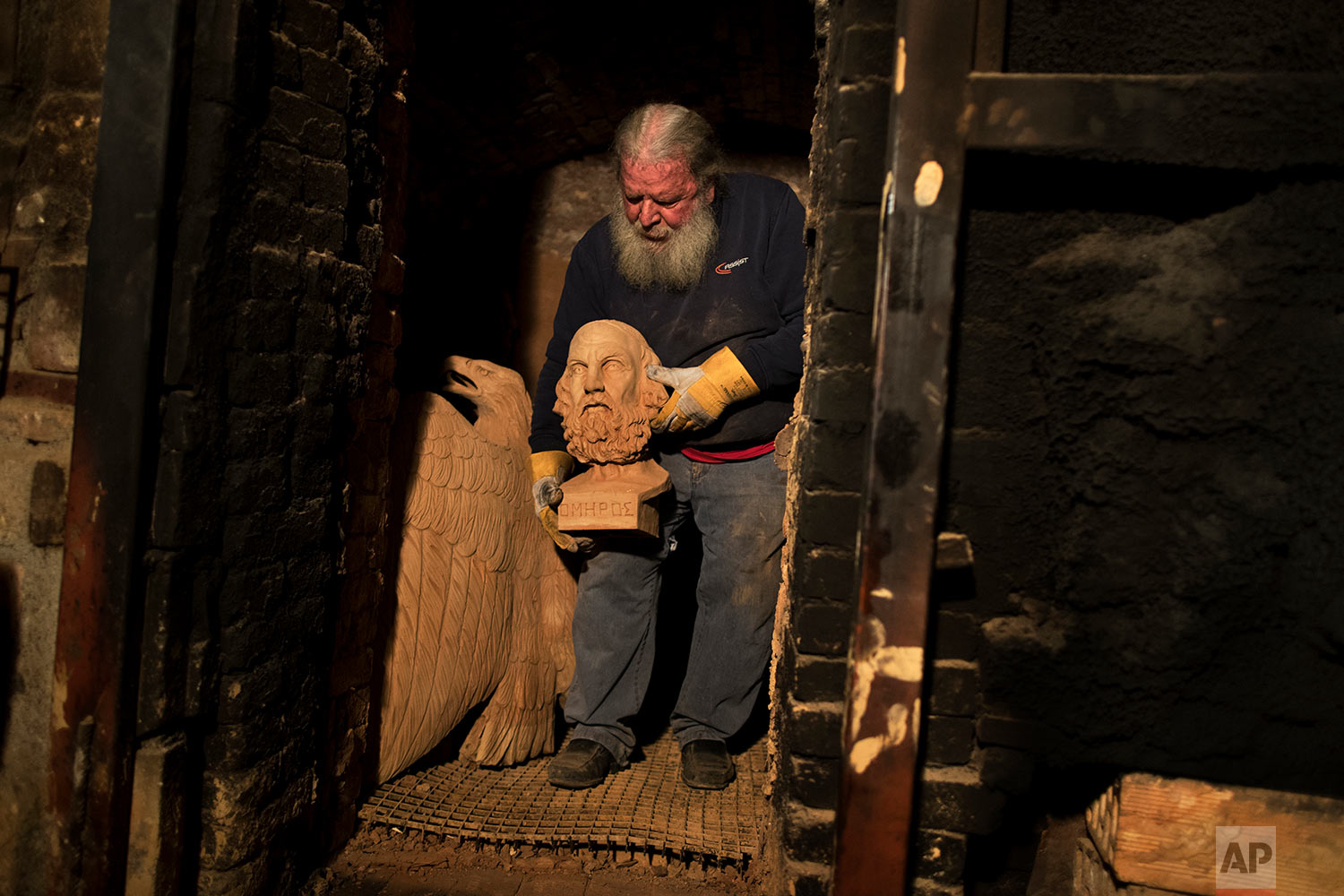  In this Thursday, Dec. 21, 2017 sculptor and ceramicist Haralambos Goumas carries out of a furnace the bust of Homer, whom Greek tradition named as the author of the Iliad and Odyssey epics, at his workshop in the Egaleo suburb of Athens. (AP Photo/