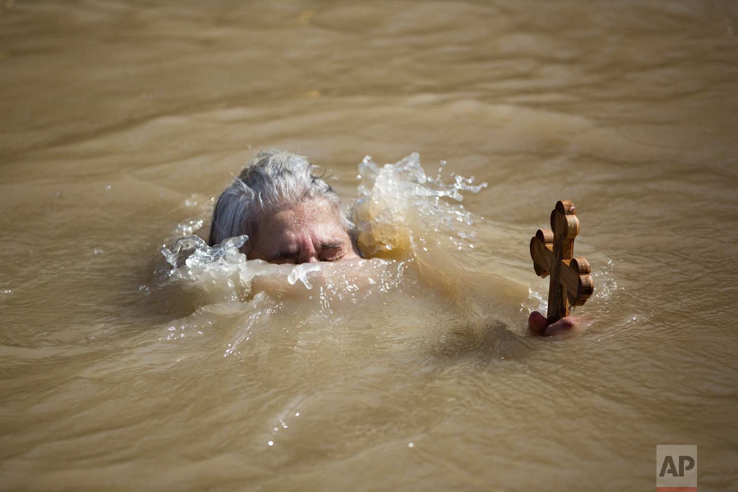  In this Wednesday, Jan. 18, 2017 photo, a Christian Orthodox pilgrim immerses herself into the waters of the Jordan River during a baptism ceremony as part of the Orthodox Feast of the Epiphany at Qasr el Yahud, the spot where John the Baptist is sa