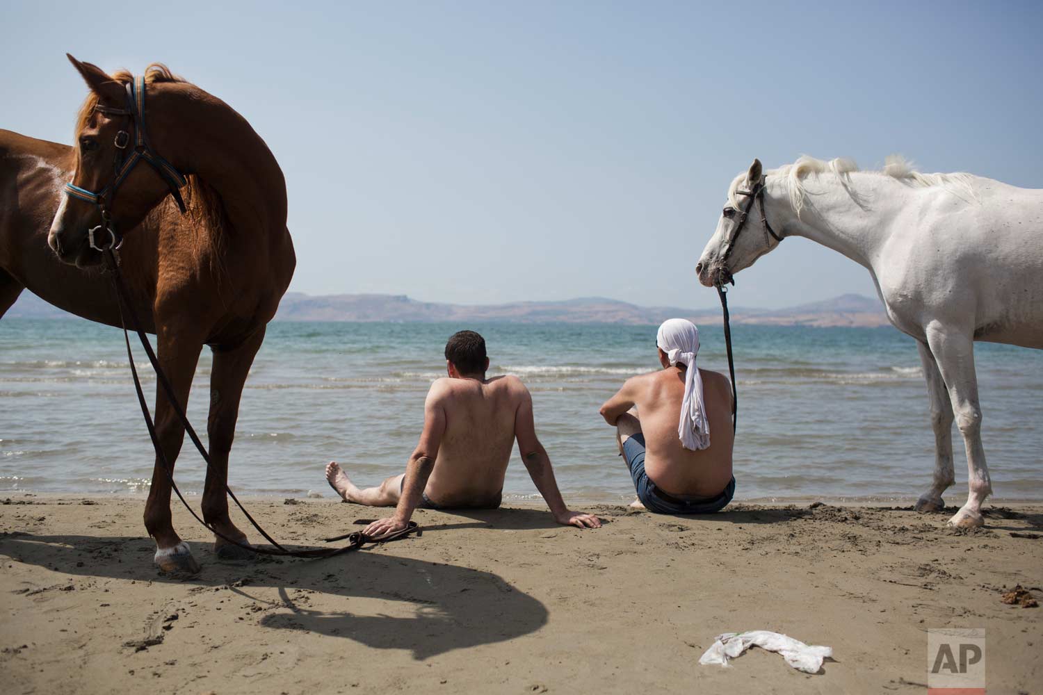  In this Saturday, Sept. 23, 2017 photo, Israeli Druse men sit with their horses on the shores of the Sea of Galilee near the northern Israeli Kibbutz of Ein Gev. (AP Photo/Oded Balilty) 