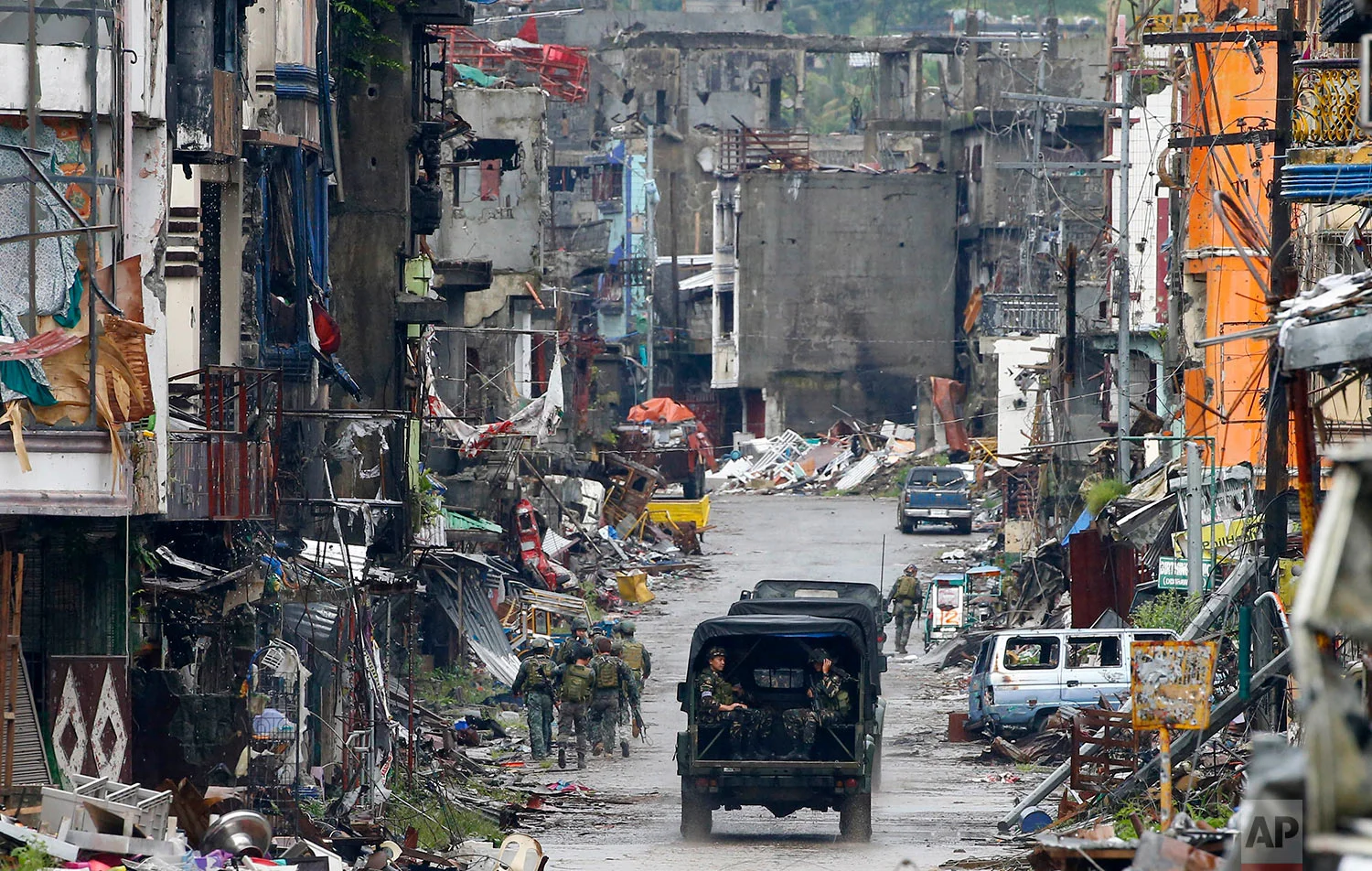 Amidst the ruins at "Ground Zero" Philippine troops return to their deployment after attending the ceremony wherein President Rodrigo Duterte declared the liberation of Marawi city in southern Philippines after almost five months of the siege by pro-Islamic State group militants Tuesday, Oct. 17, 2017. Gunfire rang out sporadically and explosions thudded as Philippine soldiers fought Tuesday to gain control of the last pocket of Marawi controlled by Islamic militants as President Duterte declared the southern city liberated from "terrorist influence." (AP Photo/Bullit Marquez)