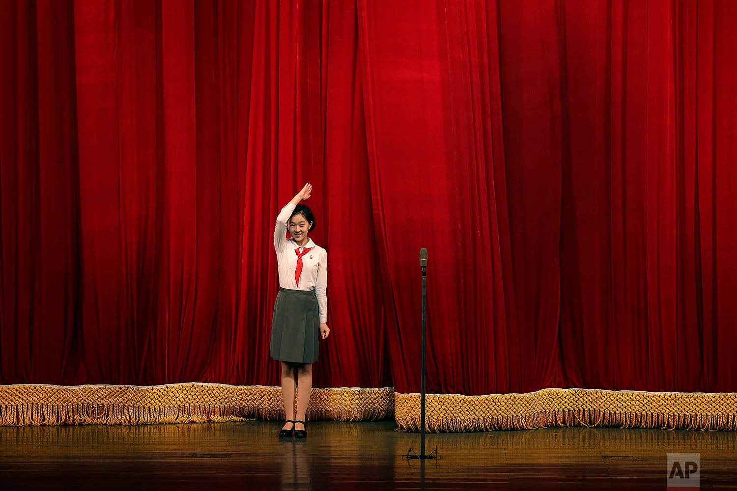 A North Korean student salutes the audience at the start of a performance at the Mangyongdae Children's Palace on Friday, April 14, 2017, in Pyongyang, North Korea. Amid rising regional tensions, Pyongyang residents have been preparing for North Korea's most important holiday: the 105th birth anniversary of Kim Il Sung, the country's late founder and grandfather of current ruler Kim Jong Un. (AP Photo/Wong Maye-E)