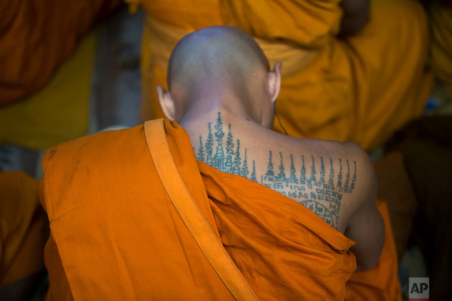 A Thai Buddhist monk with a tattooed back listens to the Tibetan spiritual leader Dalai Lama during a religious talk at the Tsuglagkhang temple in Dharmsala, India, Wednesday, June 7, 2017. Each year the Tibetan leader talks to young Tibetans on Buddhist philosophy and selected texts. The three-day talk ended Wednesday. (AP Photo/Ashwini Bhatia)