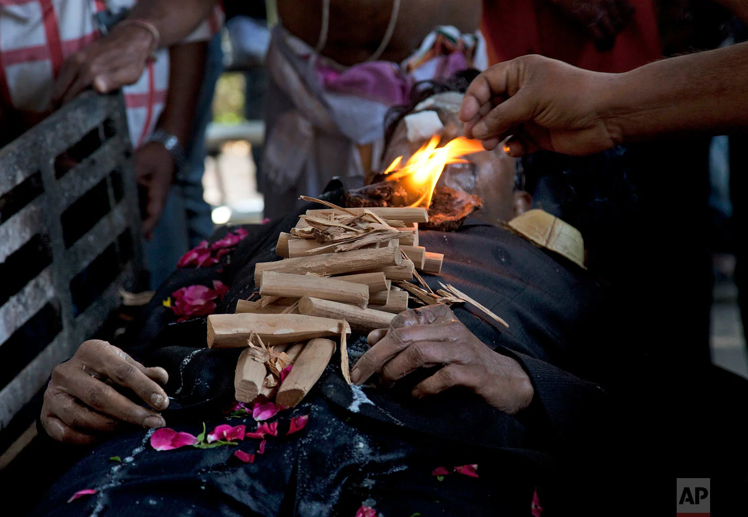 A family member performs rituals over the body of Srinivas Kuchibhotla, a 32-year-old engineer who was killed in an apparently racially motivated shooting in a crowded Kansas bar, at a crematorium in Hyderabad, India, Tuesday, Feb.28, 2017. According to witnesses, the gunman yelled "get out of my country" at Kuchibhotla and Alok Madasani before he opened fire at Austin's Bar and Grill in Olathe, Kansas, a suburb of Kansas City, on Wednesday evening. Both men had come to the U.S. from India to study and worked as engineers at GPS-maker Garmin. (AP Photo/Mahesh Kumar A.)