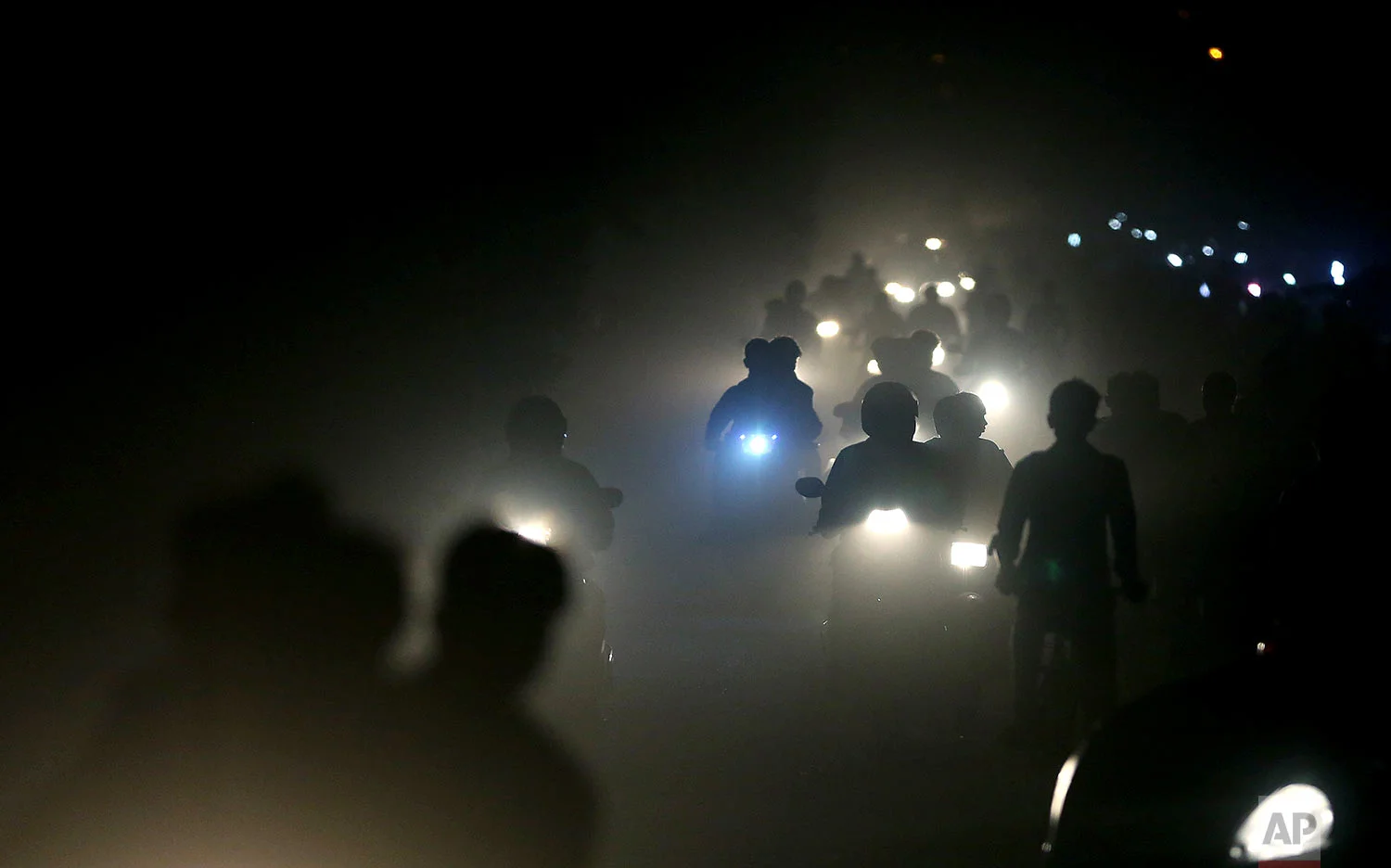 Indian motorists ride past a thick blanket of smog and dust on the outskirts of New Delhi, India, Friday, Nov. 10, 2017. Thick smog has constricted India's capital this week, smudging landmarks from view and angering residents. Many are frustrated at the lack of meaningful action by authorities. The air was the worst it has been all year in New Delhi, with microscopic particles that can affect breathing and health spiking, at times, to 75 times the level considered safe by the World Health Organization. (AP Photo/Altaf Qadri)