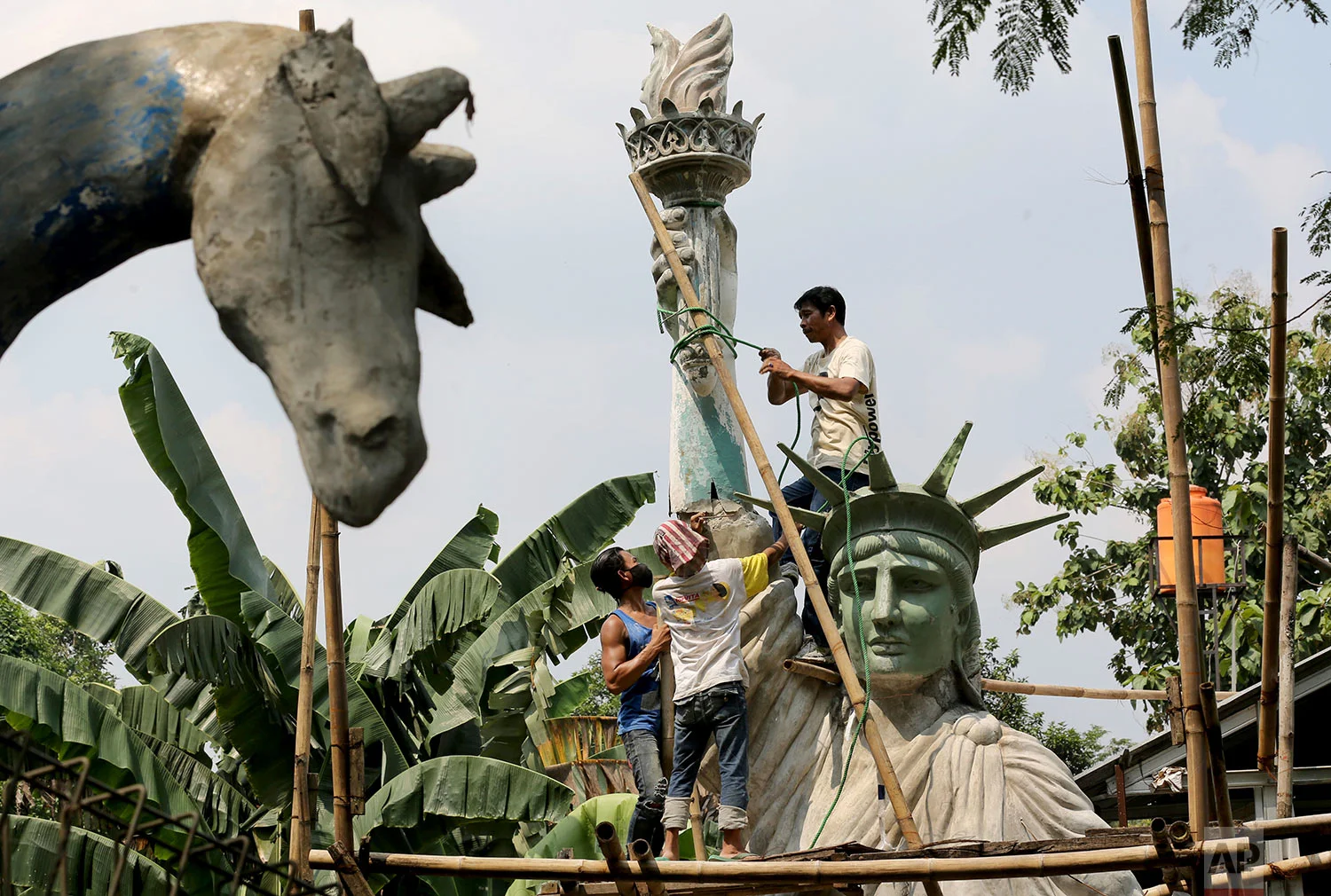 In this Thursday, May 4, 2017, photo, workers build a large replica of the Statue of Liberty at a workshop in Jakarta, Indonesia. The sculpture which costs 170 million Rupiah (U.S $ 17,000) to make will be installed at a public park to attract visitors. (AP Photo/Tatan Syuflana)