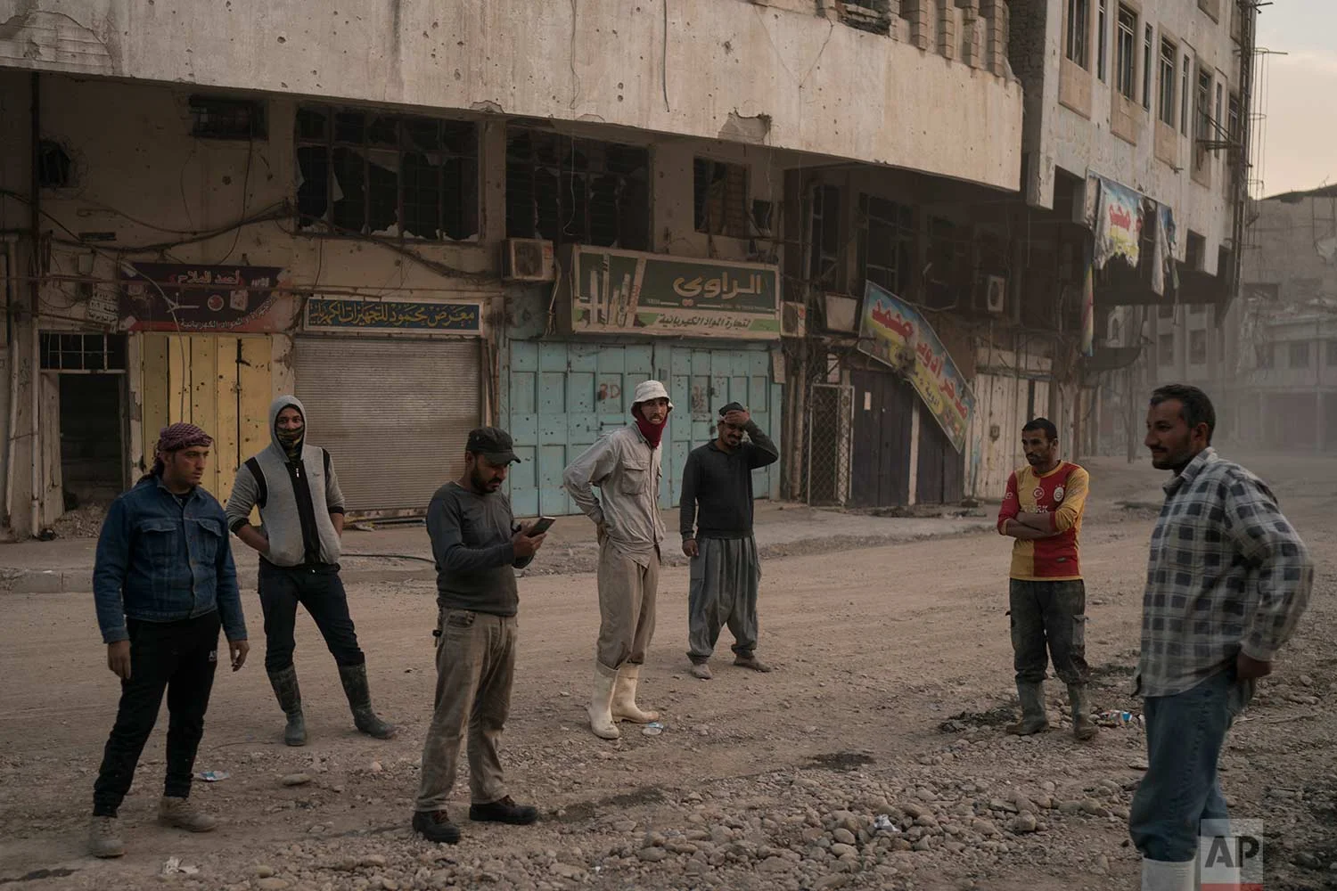 In this Nov. 15, 2017 photo, construction workers gather on a commercial street in the Old City of Mosul, Iraq. (AP Photo/Felipe Dana)