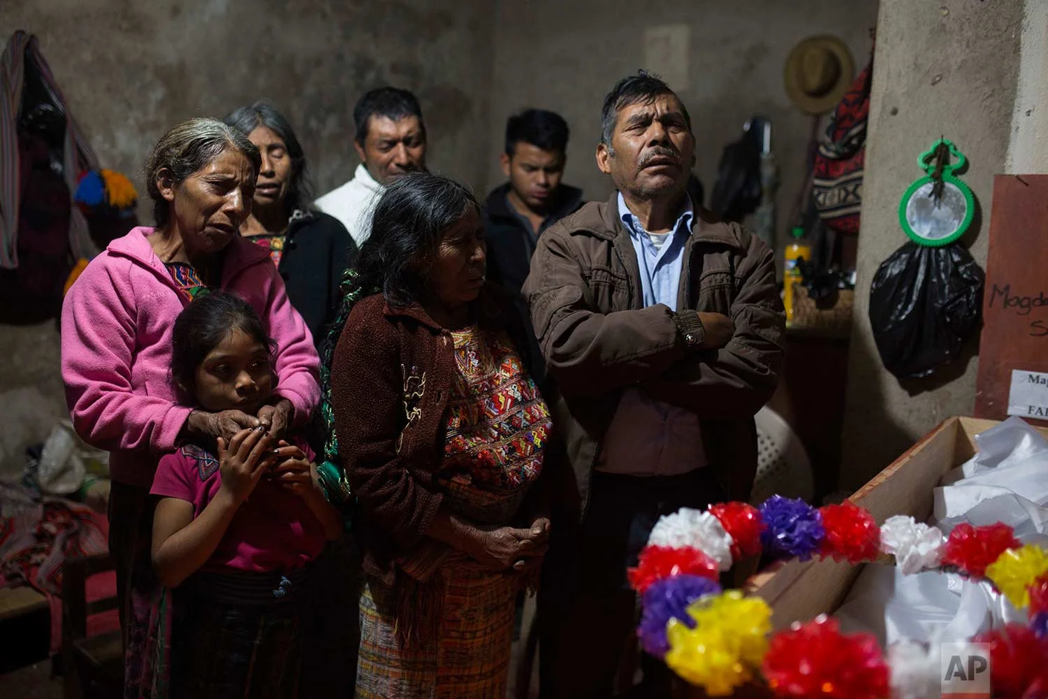 In this Nov. 29, 2017, Baltazar Perez Sanchez, 71, mourns next to the coffin of his mother Magdalena, who died at age 65, during her wake in Santa Avelina, Guatemala. Not seen in the photo are the coffins of two other relatives: Sebastien Perez Mendoza, 32, and Maria Poma Perez, 6. All three were exhumed from a grave in 2014, alongside over 100 other Ixil Mayan who died during the civil war (1978 - 1982). (AP Photo/Luis Soto)