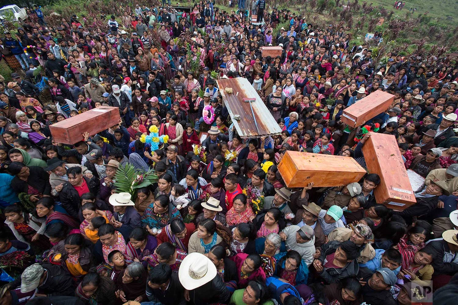 In this Nov. 30, 2017 photo, locals carry the remains of family members who were killed during the civil war, to finally be buried in Santa Avelina, Guatemala. (AP Photo/Luis Soto)