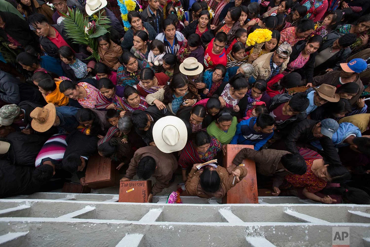 In this Nov. 30, 2017 photo, villagers place the remains of their recently identified relatives killed during the civil war, in niche graves at the cemetery of Santa Avelina, Guatemala. During the war, villages like Santa Avelina were taken over by the army, with government funds, support from U.S. evangelical churches, when then-dictator Efrain Rios Montt ruled Guatemala. About 250,000 people were killed or disappeared, overwhelmingly at the hands of soldiers. (AP Photo/Luis Soto)
