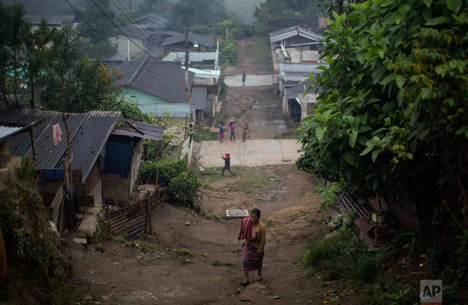 In this Nov. 30, 2017 photo, a woman walks up an unpaved road in the Ixil Mayan village of Santa Avelina, Guatemala. (AP Photo/Luis Soto)