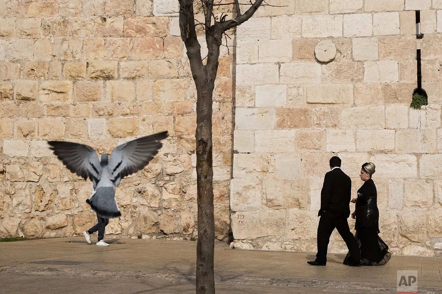 In this Saturday, Dec. 23, 2017 photo, people walk along the Jerusalem's Old City walls, next to Jaffa Gate. (AP Photo/Oded Balilty)