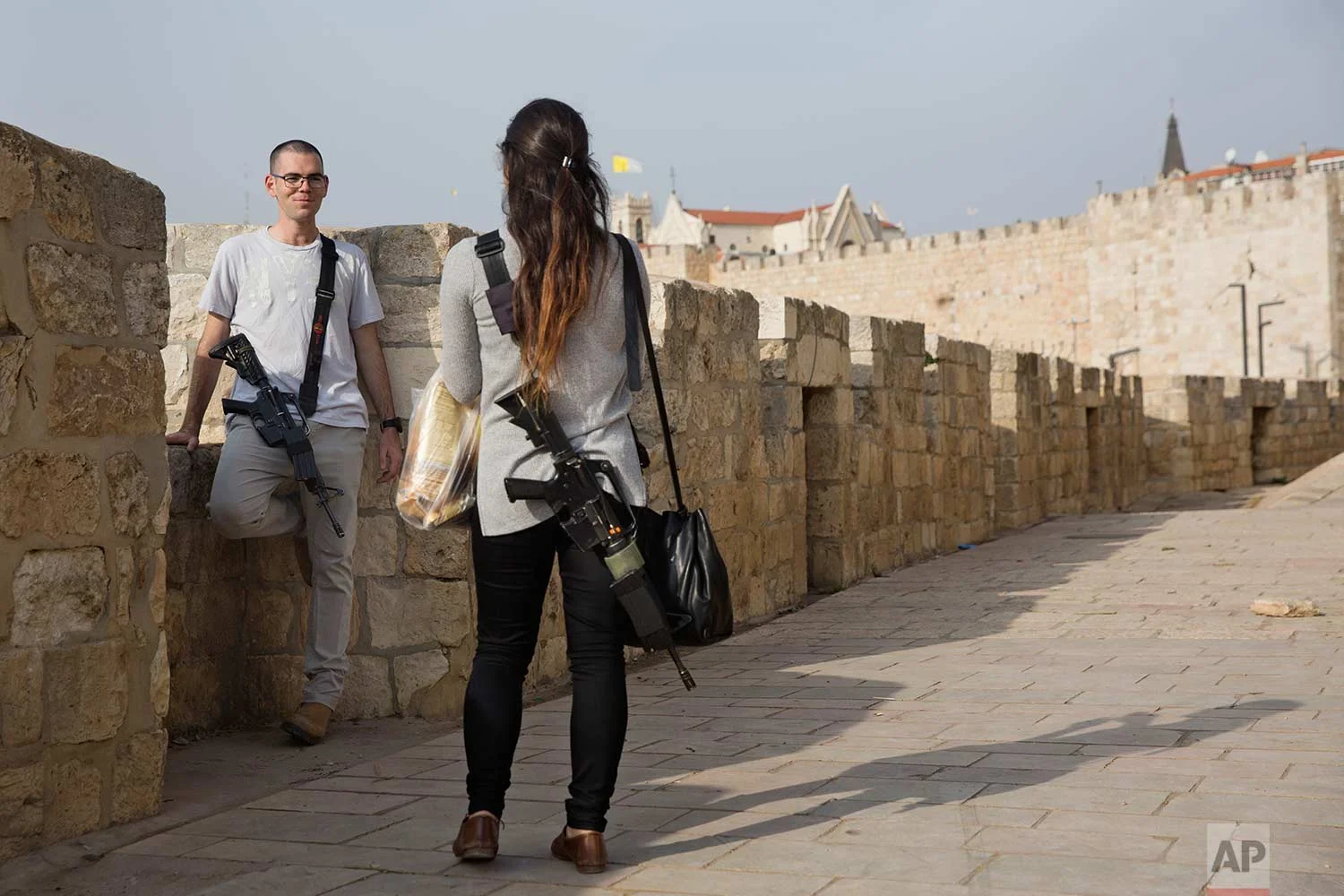 In this Saturday, Dec. 23, 2017 photo, an Israeli soldier on their weekend time off carrying their unloaded M-16 rifle as they tour in Jerusalem Old City. (AP Photo/Oded Balilty)