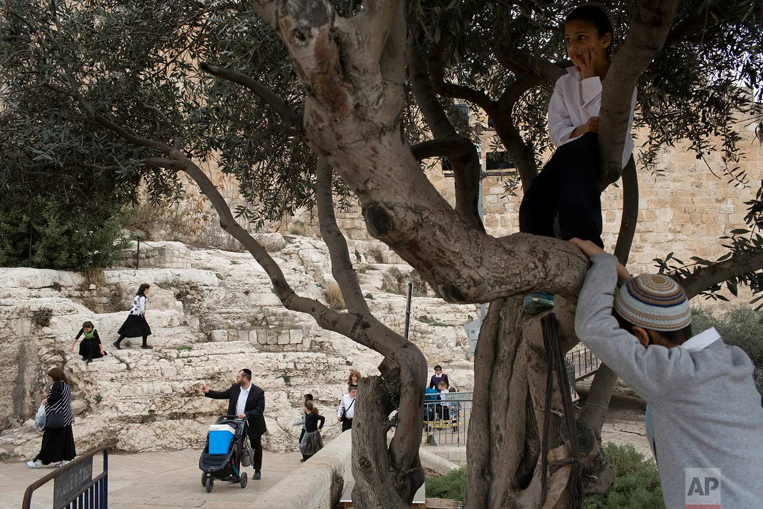 In this Tuesday, Dec. 19, 2017 photo, Israelis walks along the Jerusalem Old City walls during the Jewish holiday of Hanukkah. (AP Photo/Oded Balilty)