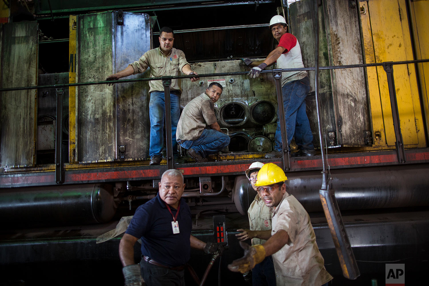  In this Nov. 1, 2017 photo, workers repair a locomotive at Ferrominera Orinoco, in Ciudad Guayana, Bolivar state, Venezuela. In cash-strapped Venezuela, there's no money to buy spare parts. (AP Photo/Rodrigo Abd) 