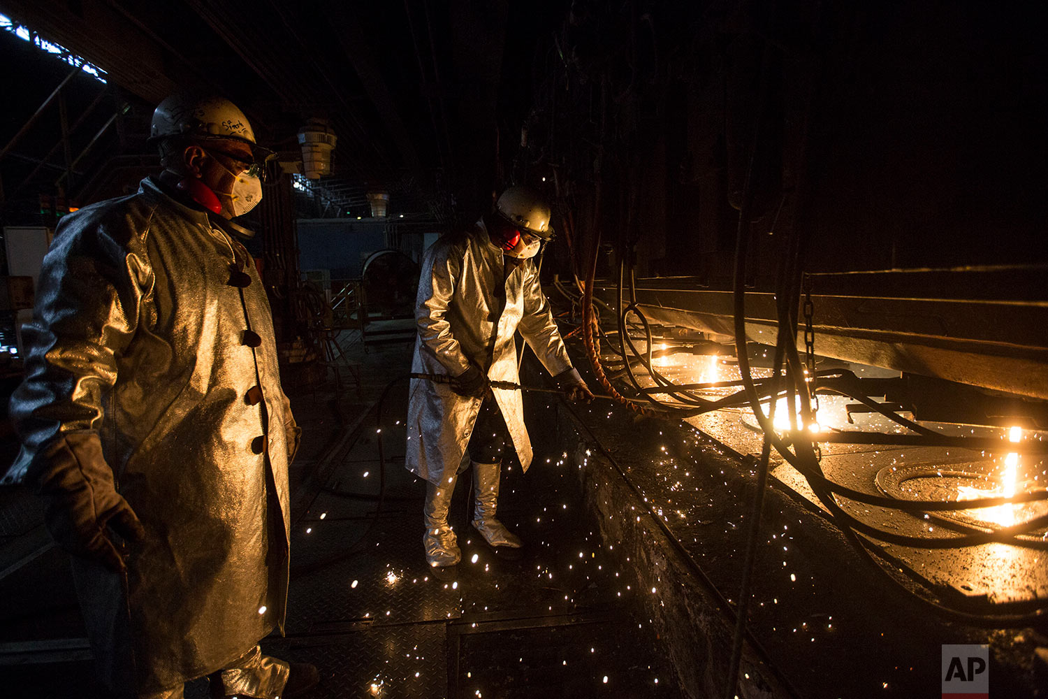  In this Nov. 7, 2017 photo, workers clean the candles, at Sidor's Palanquilla plant, in Ciudad Guayana, Bolivar state, Venezuela. In Sidor, only two of the four smelting ovens that make steel bars are functioning, and workers who used to operate aro