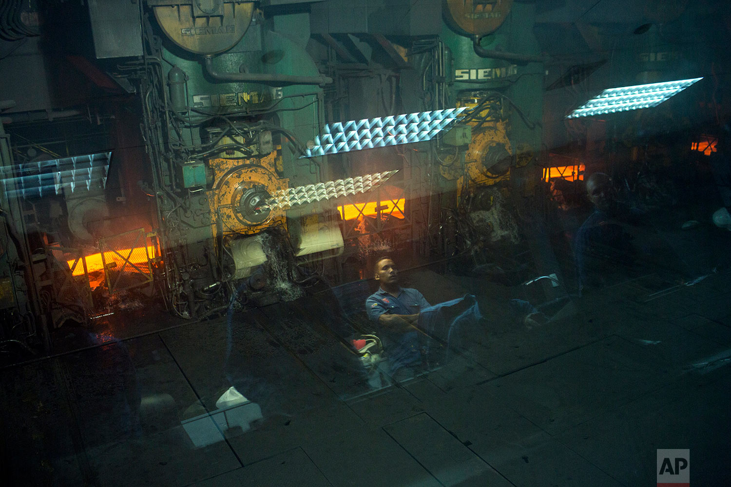  In this Nov. 6, 2017 photo, workers are reflected on a window at the Sidor steel mill, in Ciudad Guayana, Bolivar state, Venezuela. Ciudad Guyana was long seen as the future of Venezuela. U.S. companies in the 1950s zeroed in on Venezuela's vast res