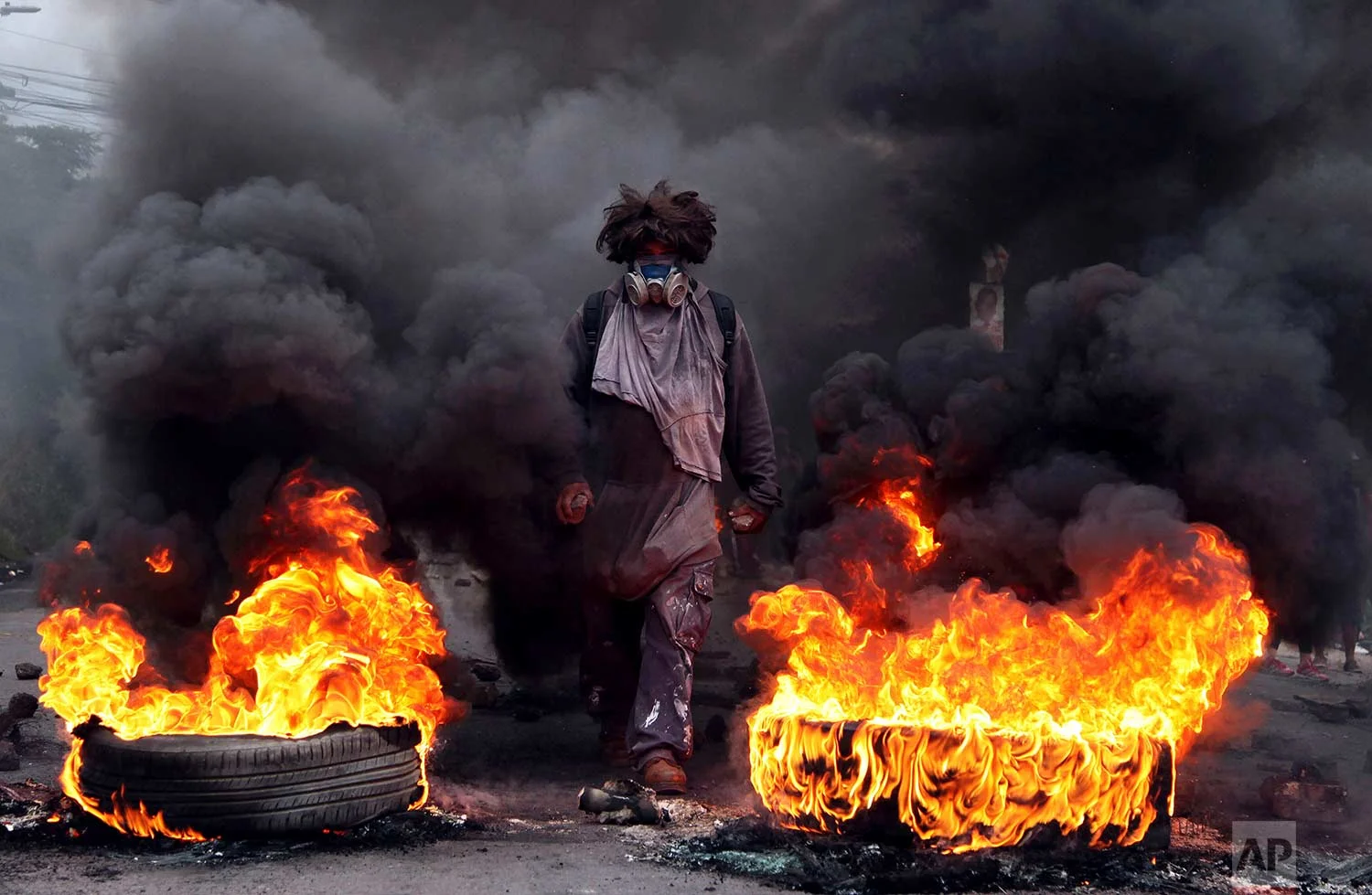 In this Dec. 22, 2017 photo, an anti-government protestor blocks a road, on the outskirts of Tegucigalpa, Honduras. (AP Photo/Fernando Antonio)