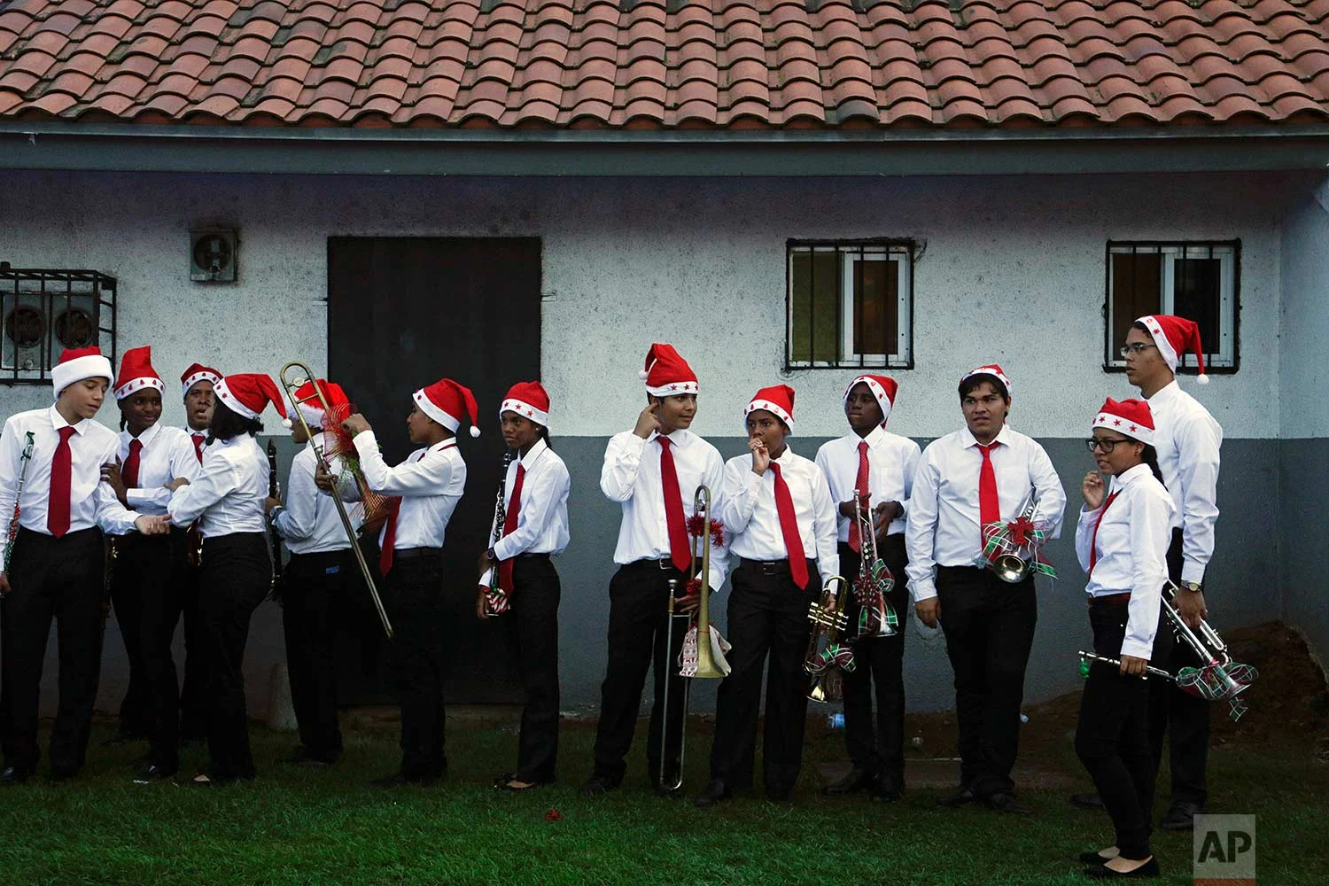 High school student music band members wait to play in the annual Christmas parade in Panama City, Sunday, Dec. 10, 2017. (AP Photo/Arnulfo Franco)