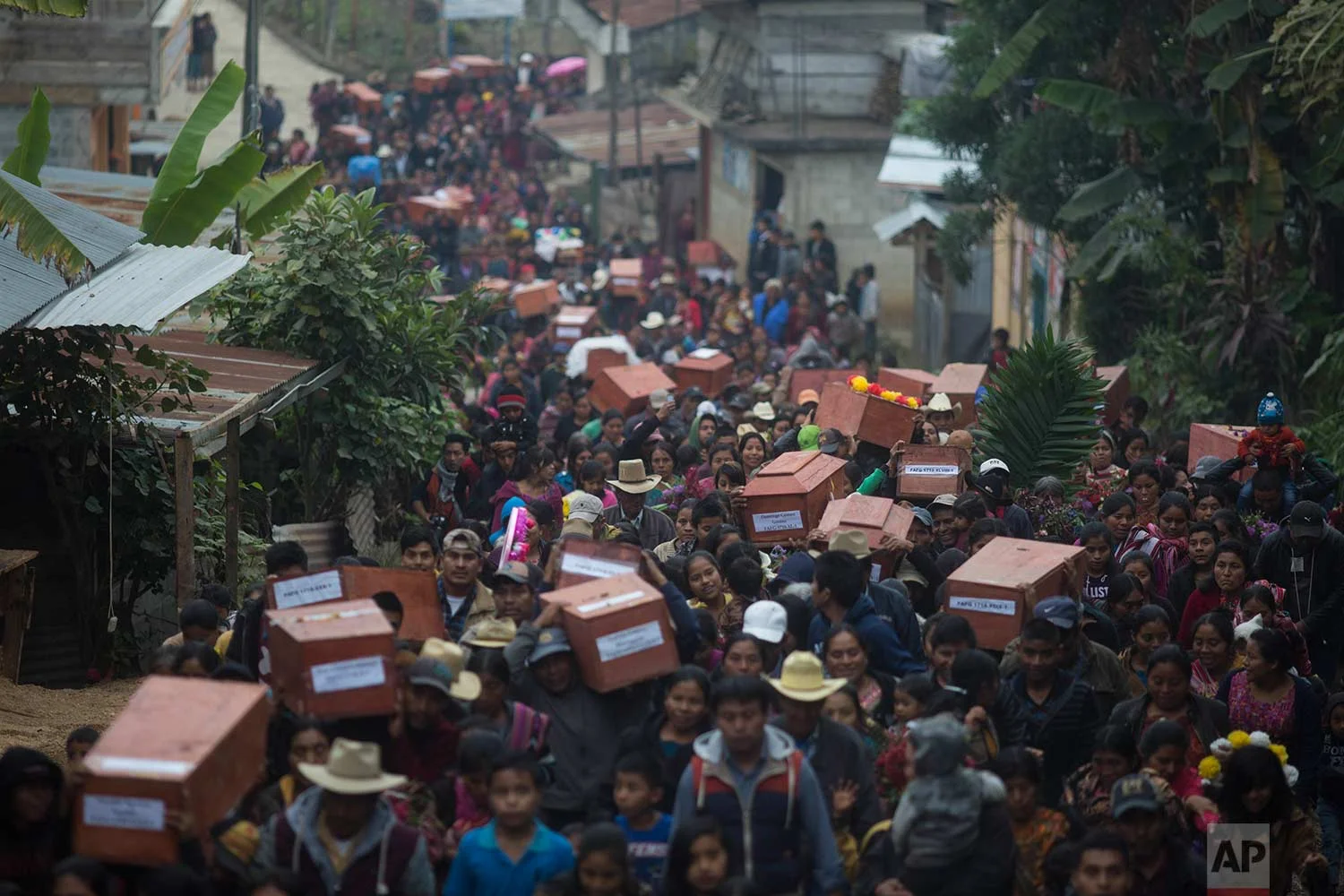 In this Nov. 30, 2017 photos, Ixil Mayans carry the remains of their loved ones killed during the civil war to the cemetery for burial in Santa Avelina, Guatemala. (AP Photo/Luis Soto)