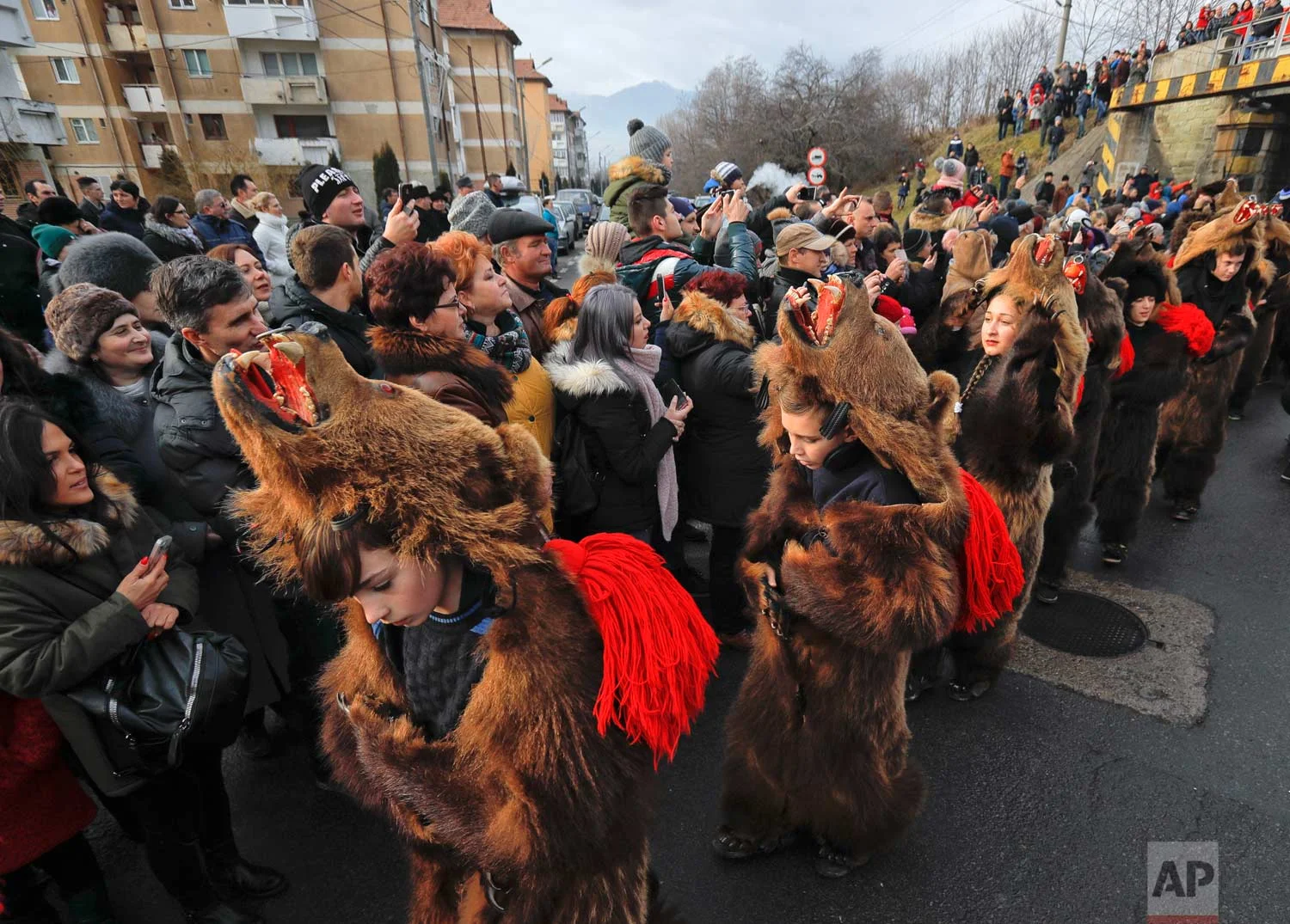 In this Saturday, Dec. 30, 2017, picture people watch an annual bear parade in Comanesti, Romania. (AP Photo/Vadim Ghirda)