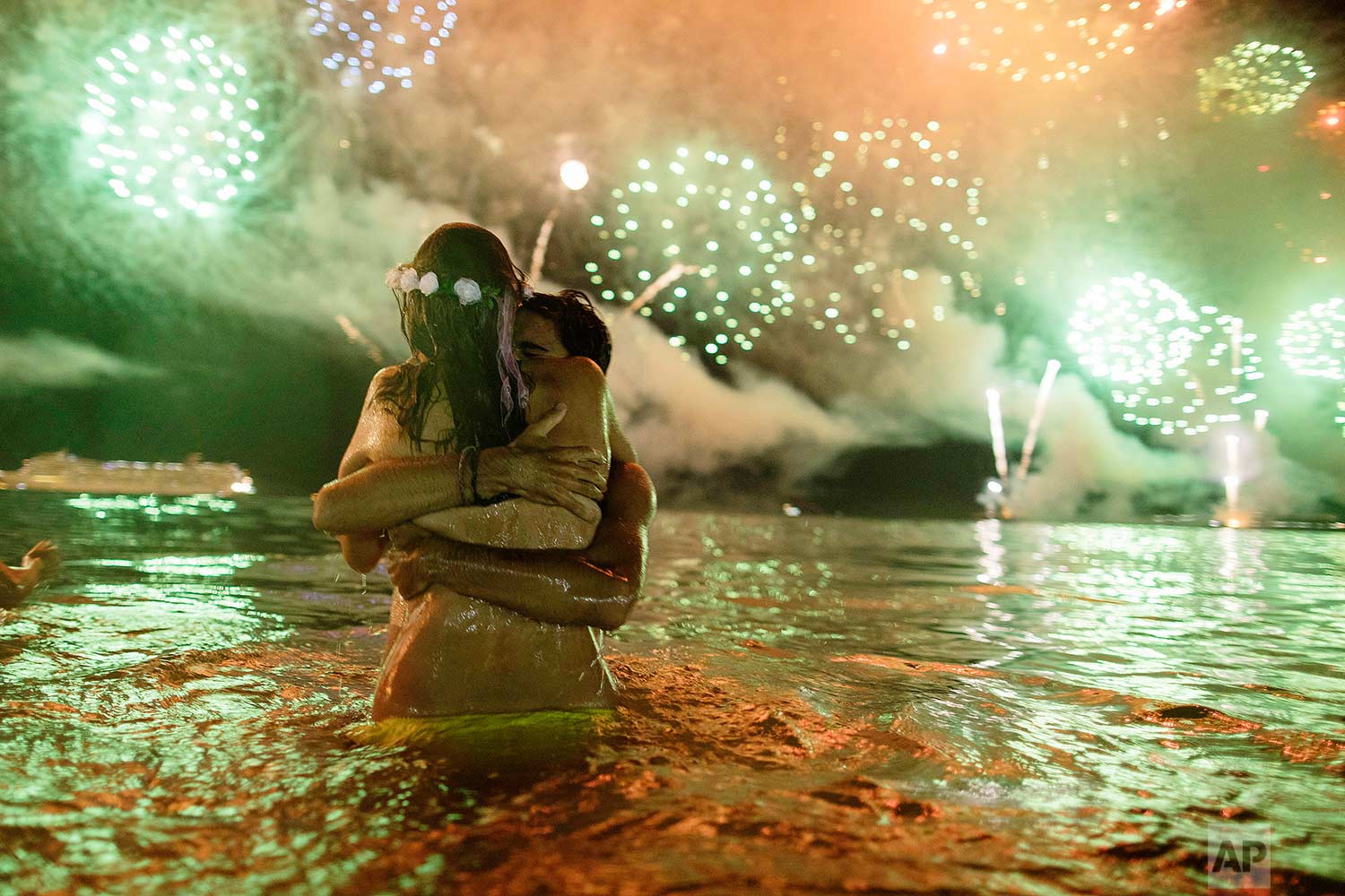  A couple hug each other as they watch fireworks burst over Copacabana beach during New Year's celebrations in Rio de Janeiro, Brazil, on Monday, Jan. 1, 2018. (AP Photo/Leo Correa) 